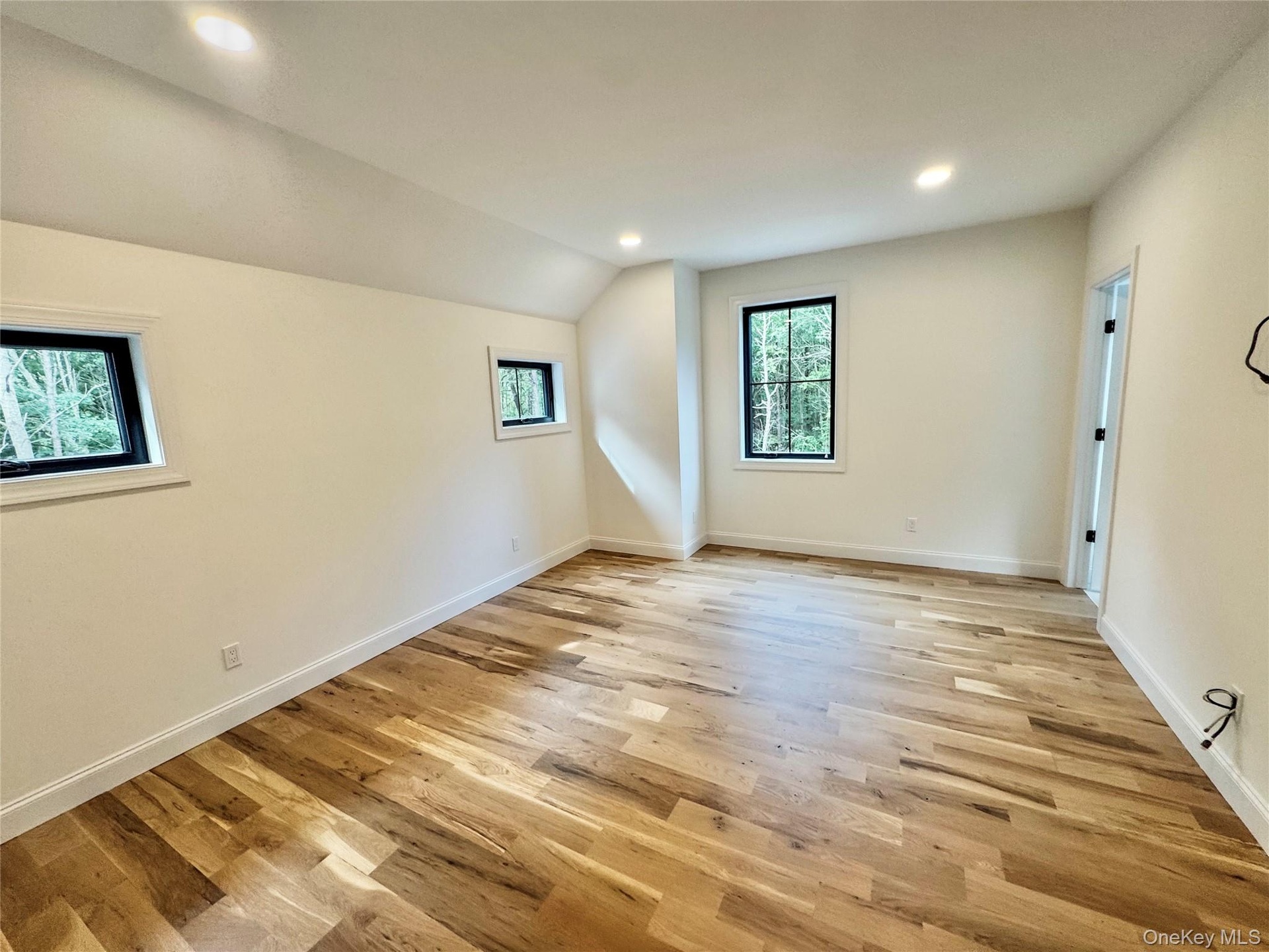 Unfurnished room featuring recessed lighting, light wood-style flooring, and lofted ceiling