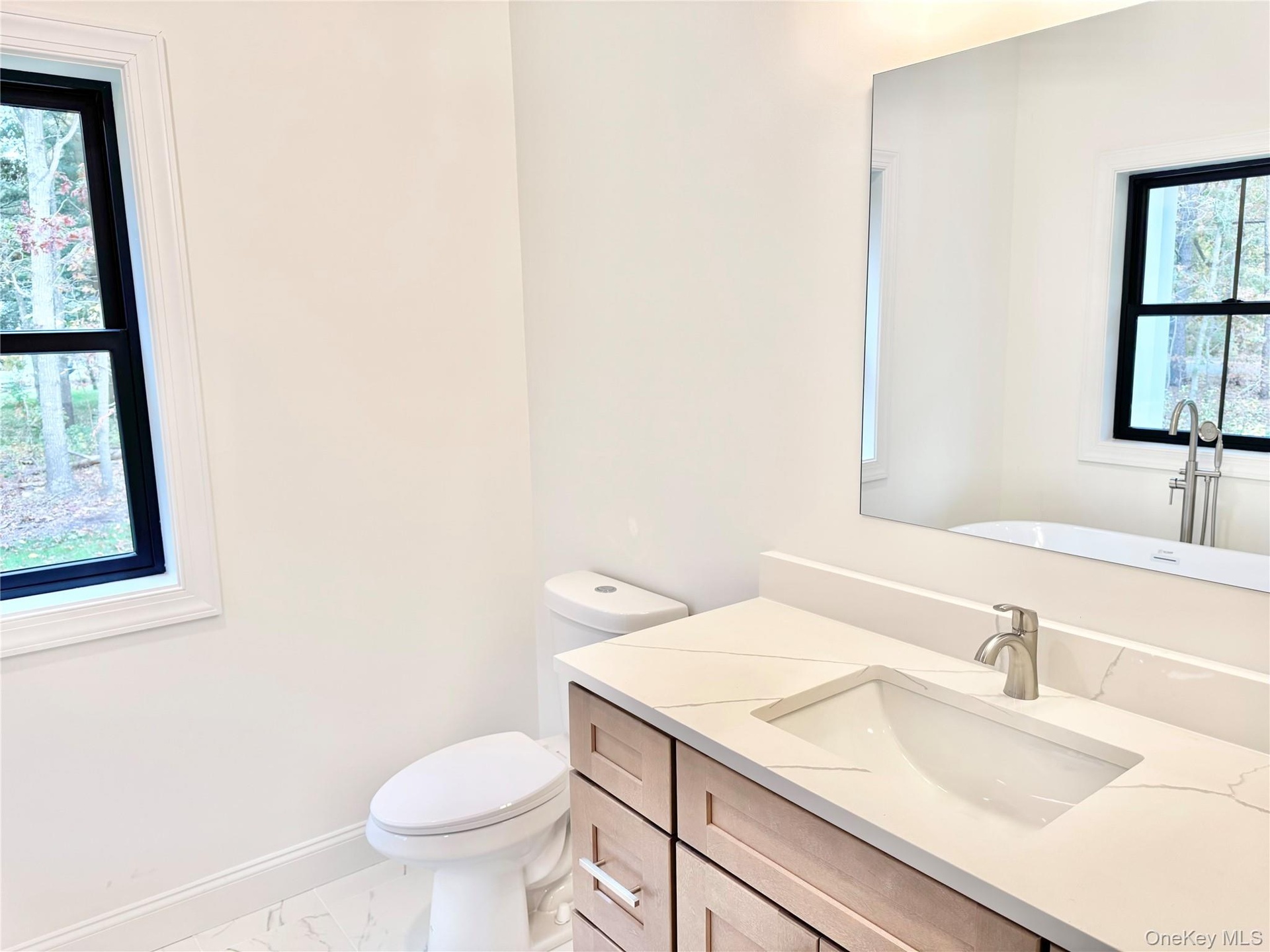 Bathroom with vanity and marble finish flooring
