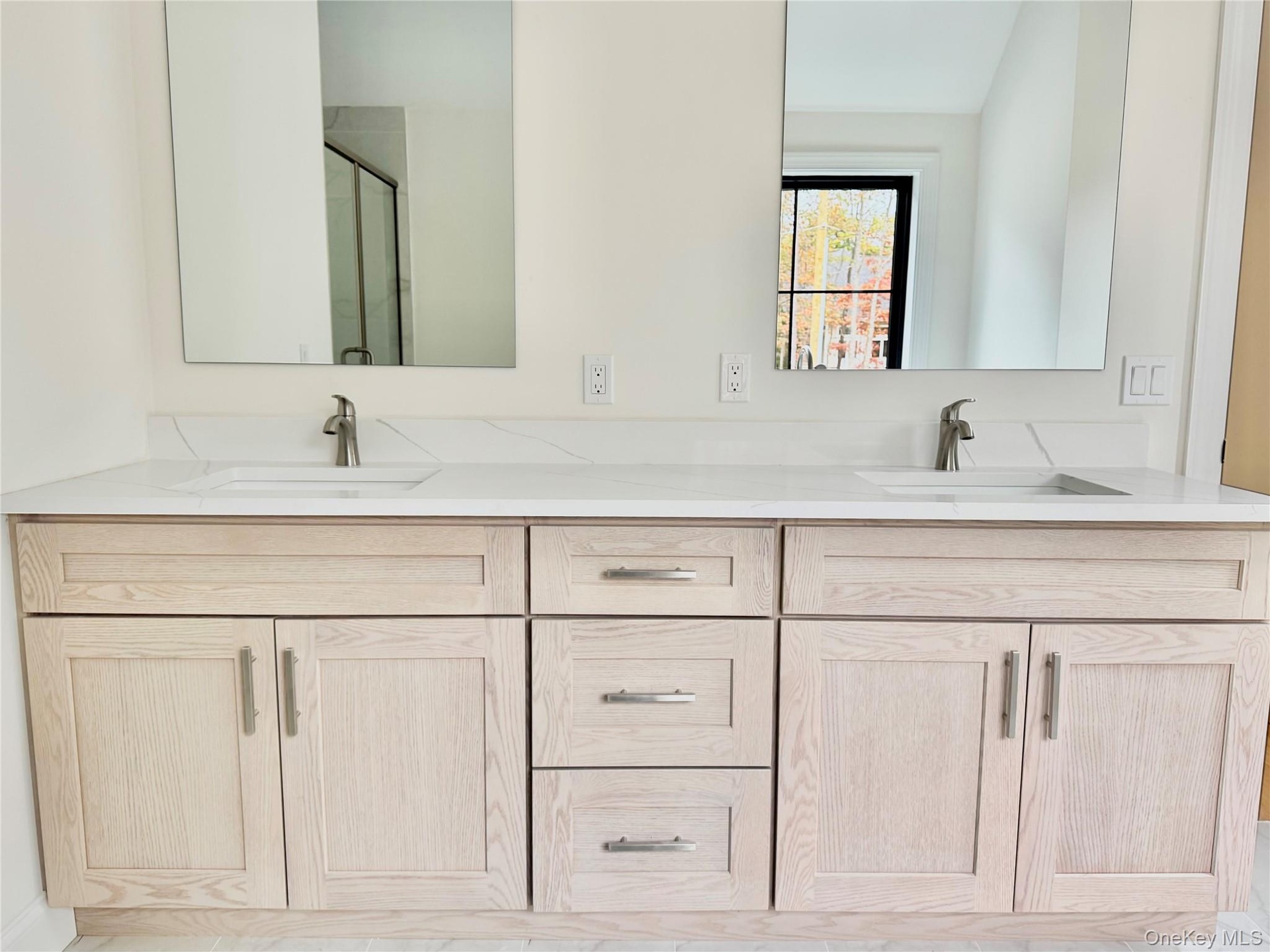 Bathroom featuring double vanity and a shower stall