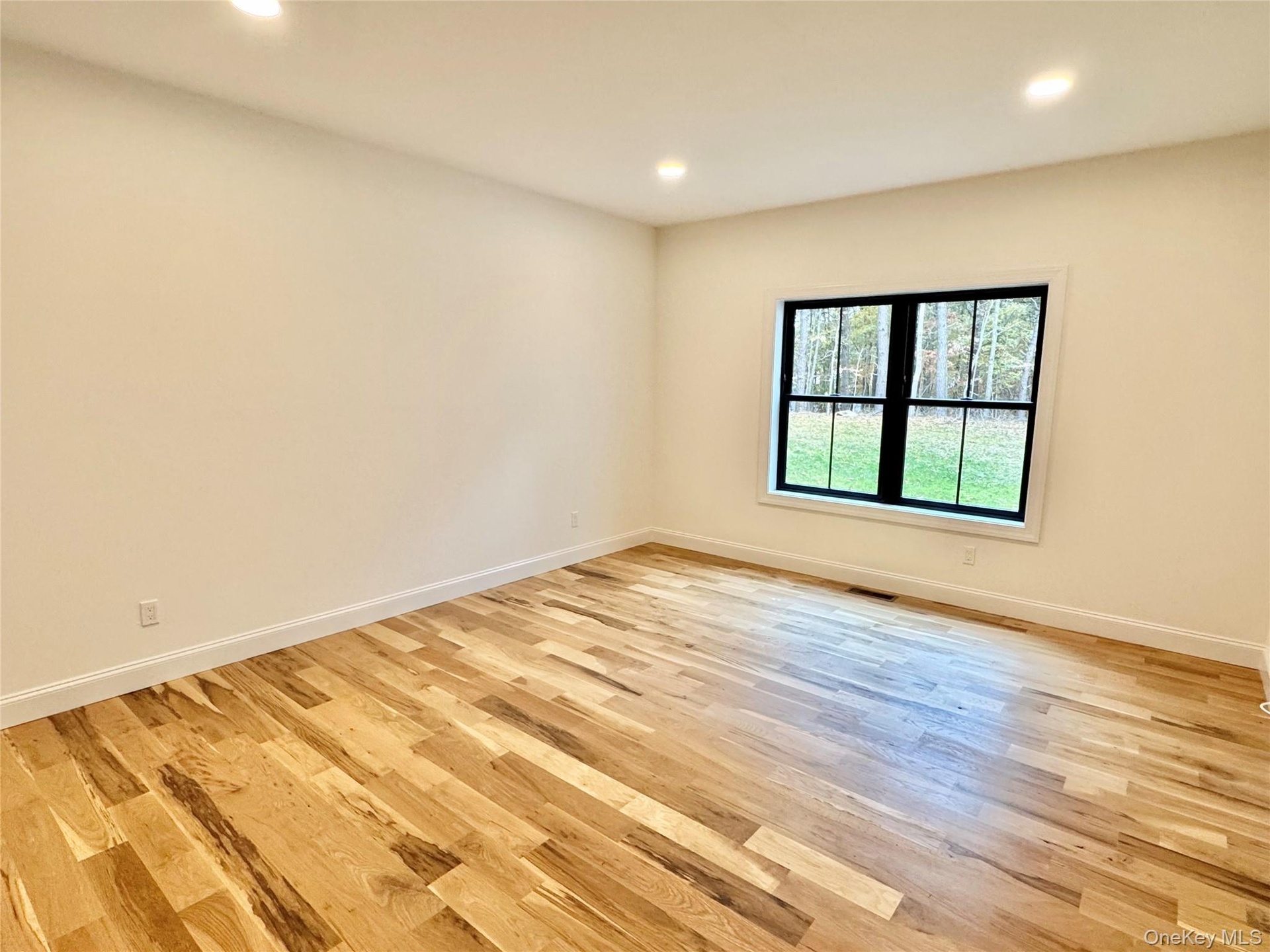 Empty room with recessed lighting and light wood-style flooring