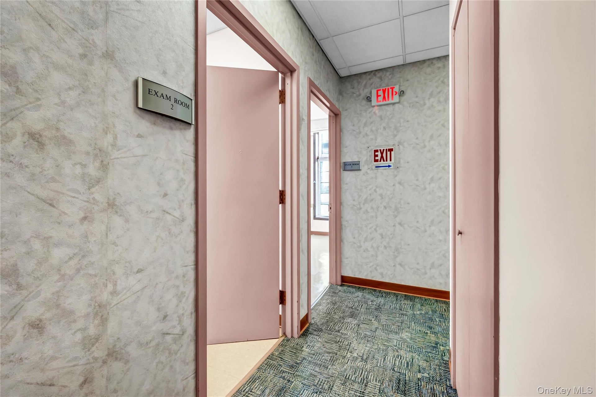 Corridor with carpet flooring and a paneled ceiling