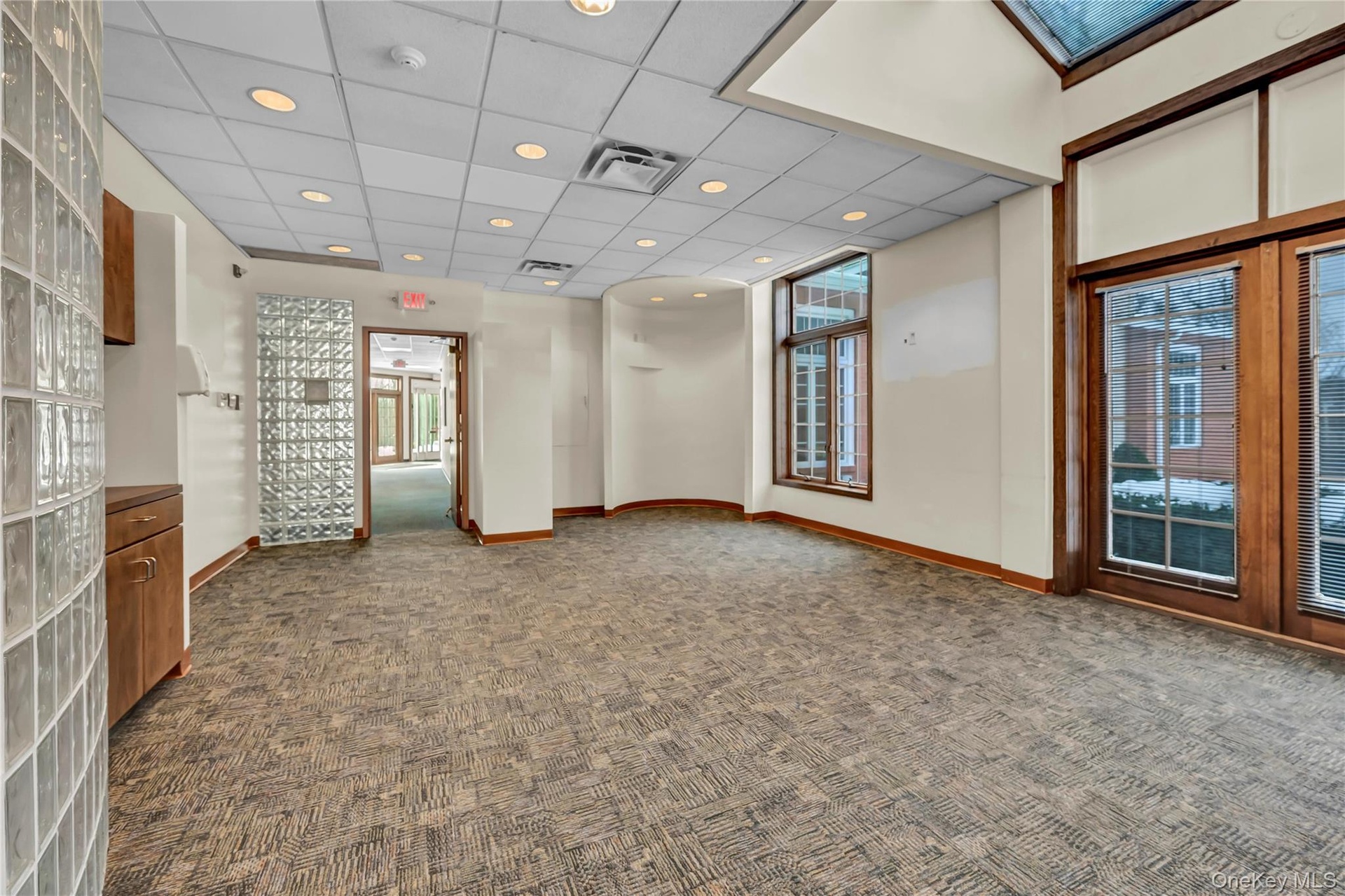 Empty room featuring a drop ceiling and dark carpet