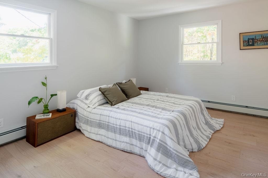 Neutral interior featuring light wood-finish flooring, two double-hung windows, and crisp wall paint