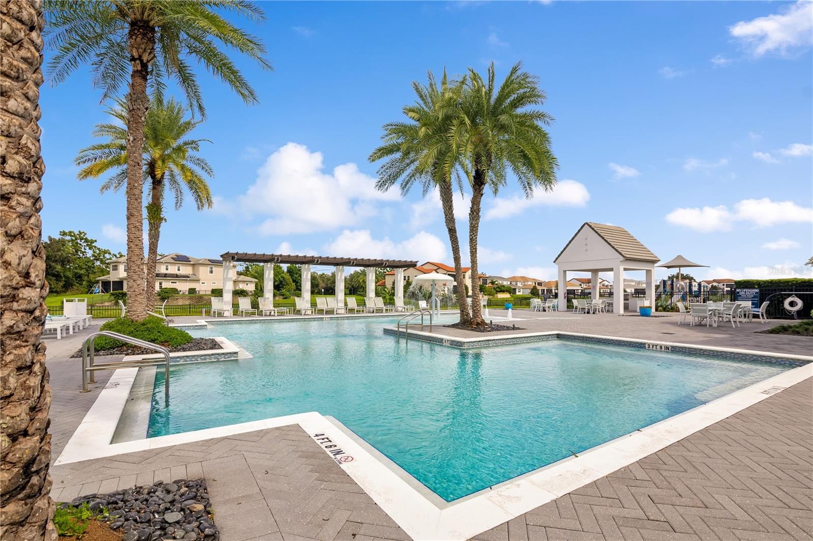 Relax and unwind at the stunning resort-style community pool surrounded by tropical landscaping.