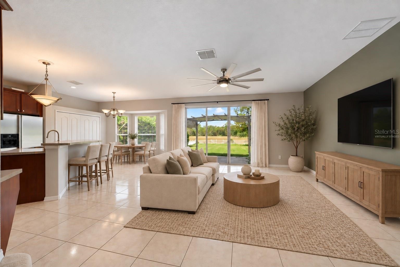 The Kitchen flows seamlessly into the Family Room, where triple sliding glass doors bring in NATURAL LIGHT and open to the back patio, extending the l