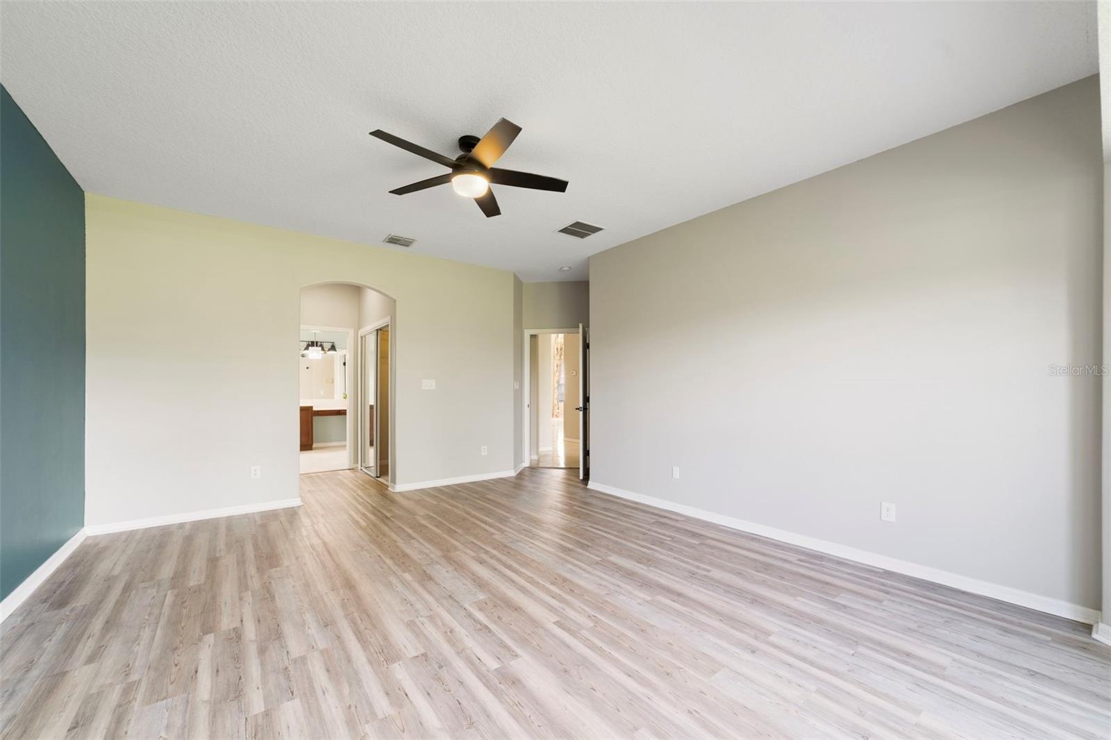 The FIRST-FLOOR PRIMARY SUITE presents a private retreat with LVP FLOORING and a bay window that fills the room with NATURAL LIGHT.