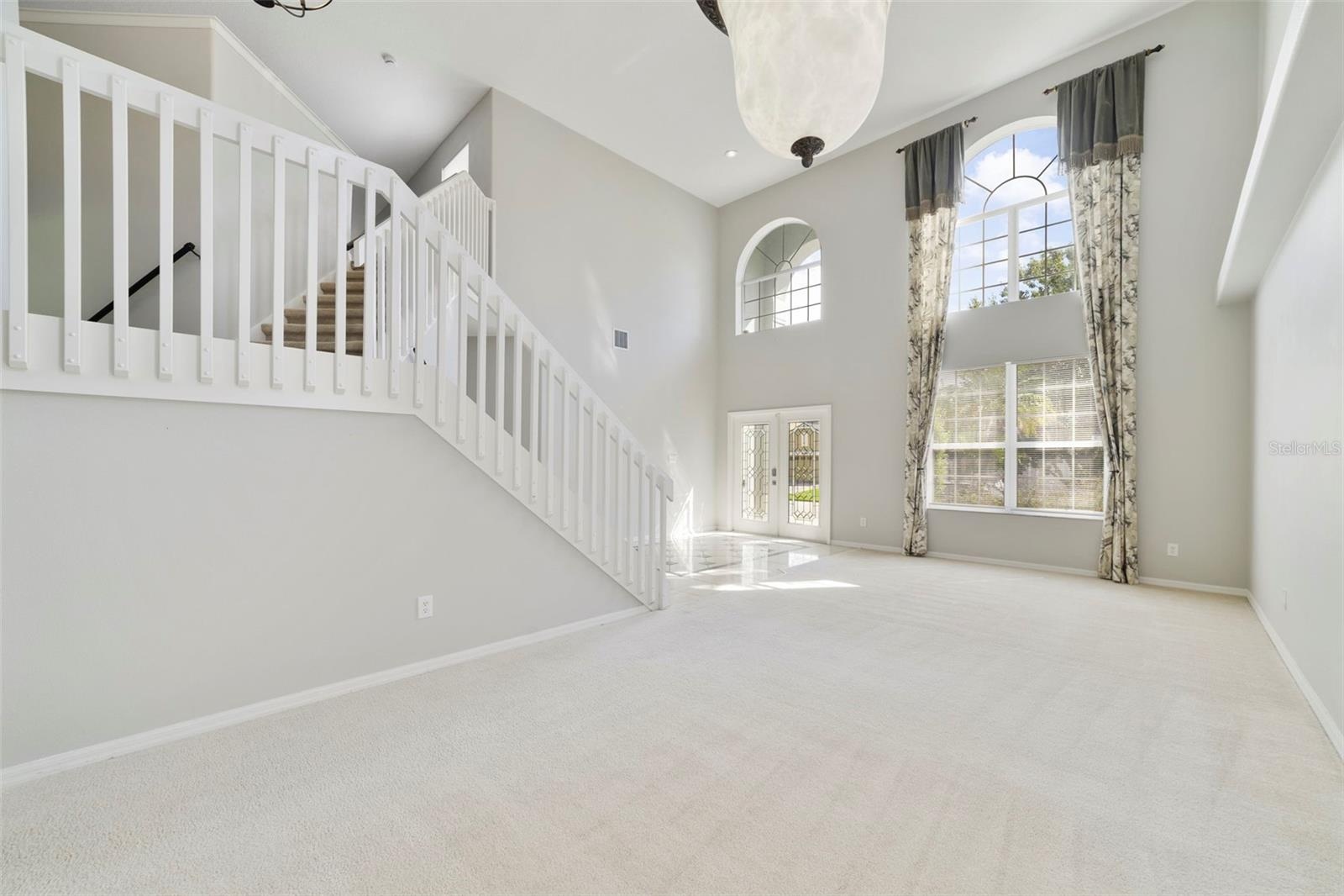 The formal LIVING ROOM/DINING ROOM COMBO share an elegant, open setting enhanced by 2-STORY CEILINGS where a chandelier and decorative ceiling medalli