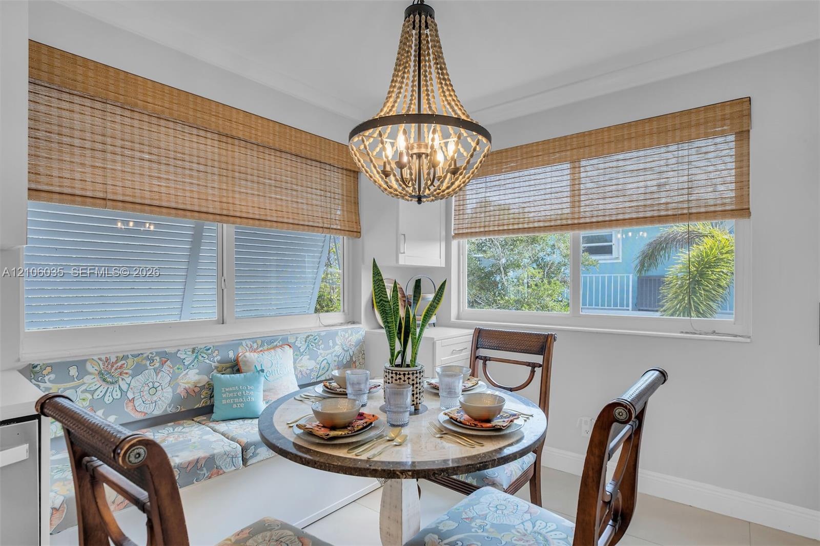 Beaded empire chandelier, custom built-in window seating, and woven wood window shades