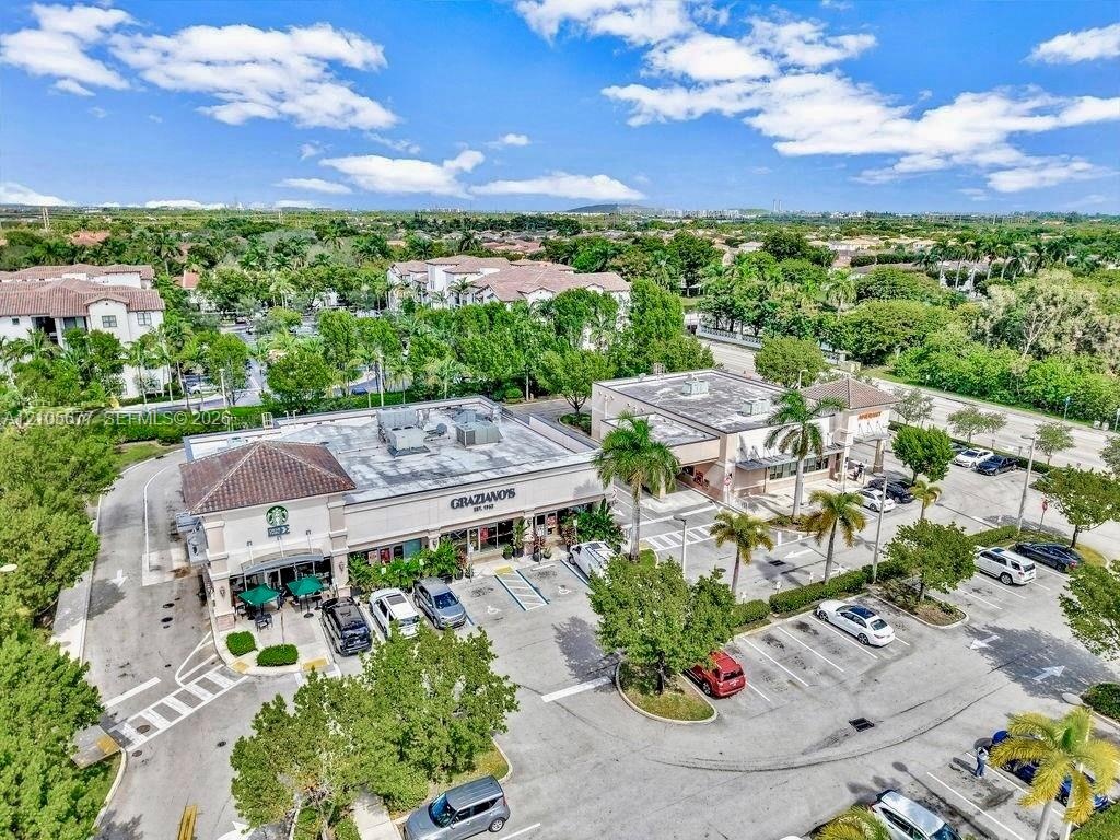 Commercial retail center featuring a paved parking lot, mature palm tree landscaping, and direct street frontage