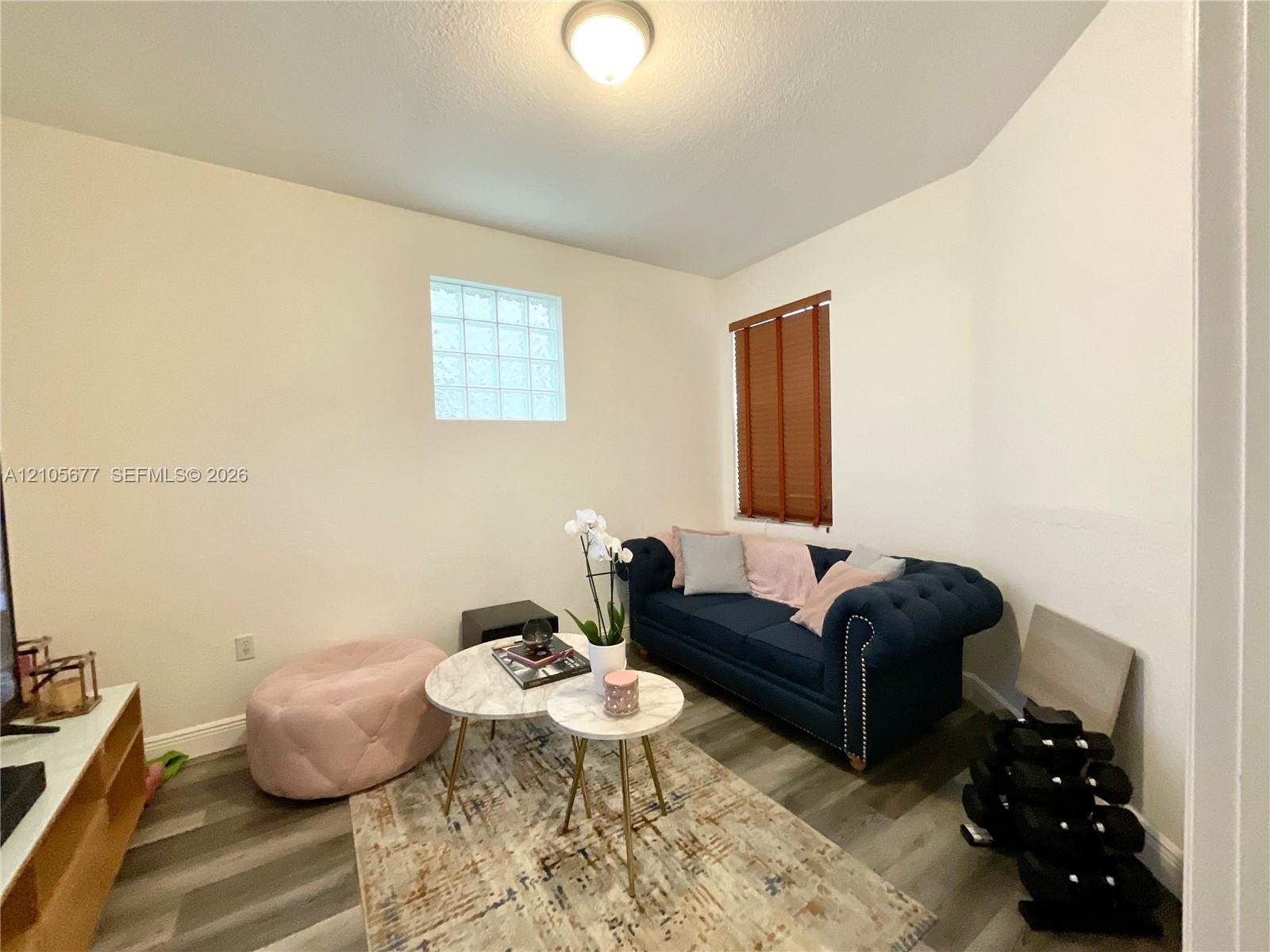 Wood-finish flooring, glass block window, and flush-mount ceiling lighting