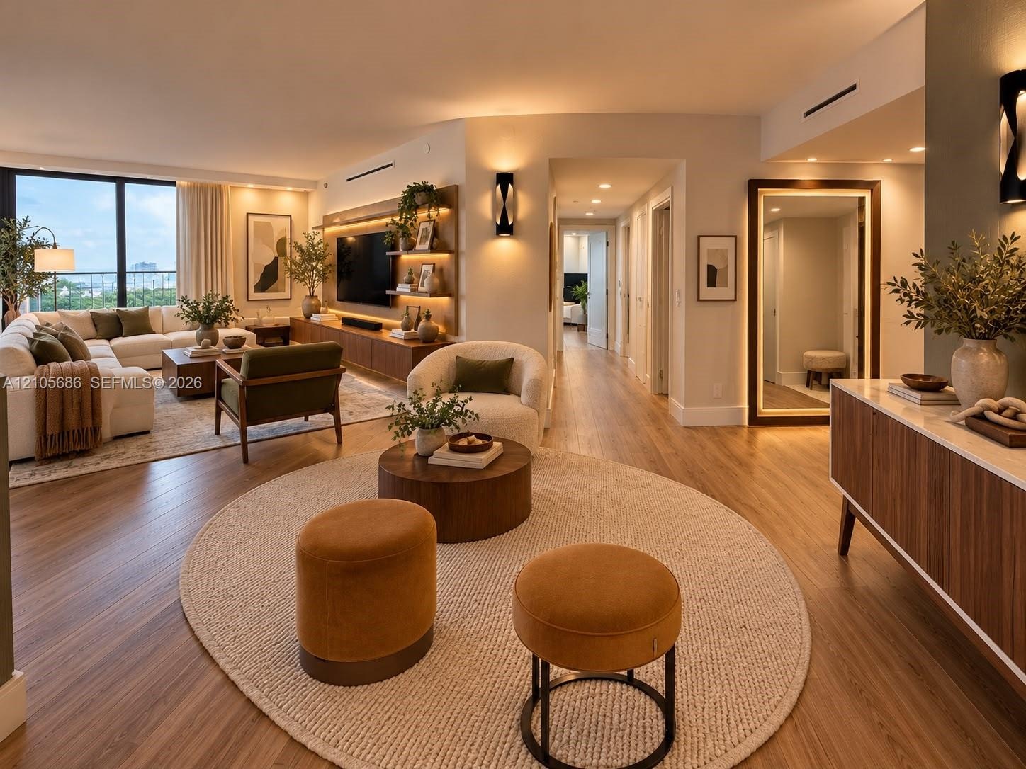 Open-concept living space featuring wood-finish flooring, custom built-in cabinetry with integrated shelving and recessed lighting, floor-to-ceiling w