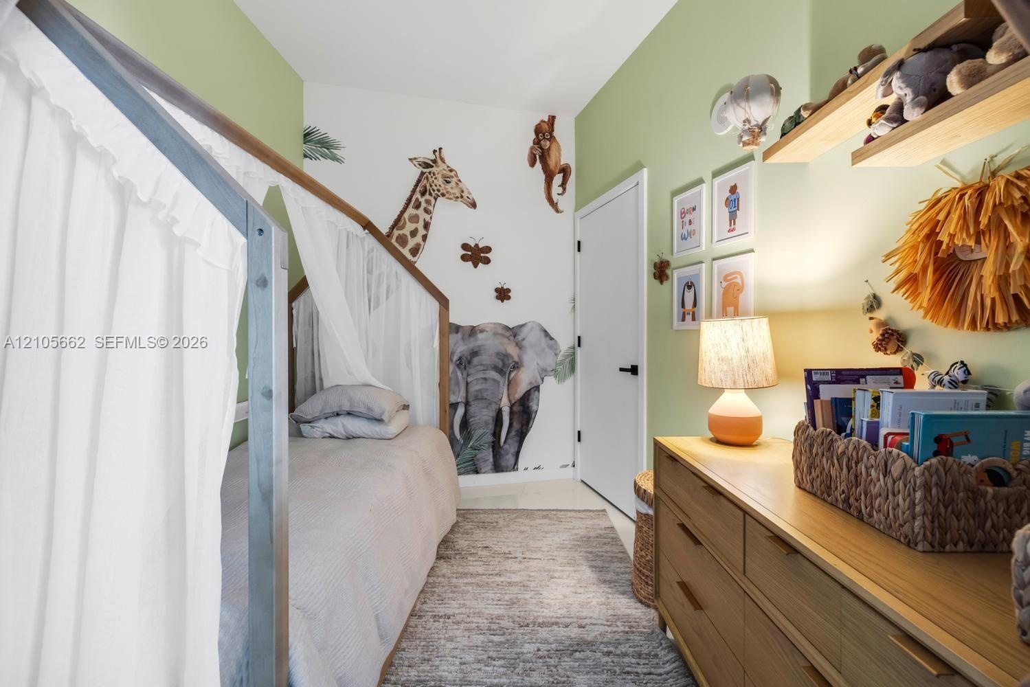 Room featuring light green painted walls, white door with matte black hardware, and wall-mounted wooden shelving