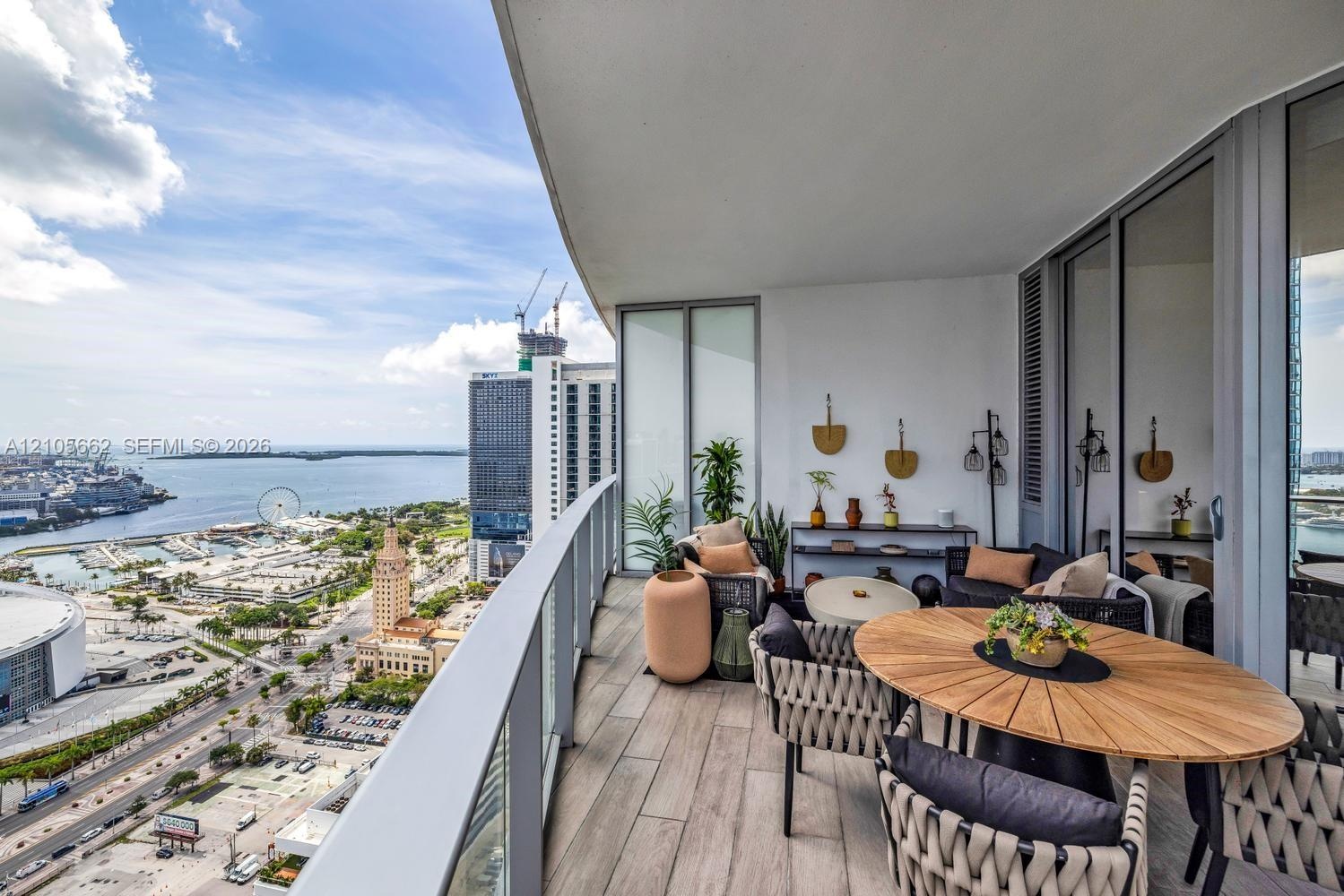 Expansive covered balcony featuring wood-finish flooring and a tempered glass railing