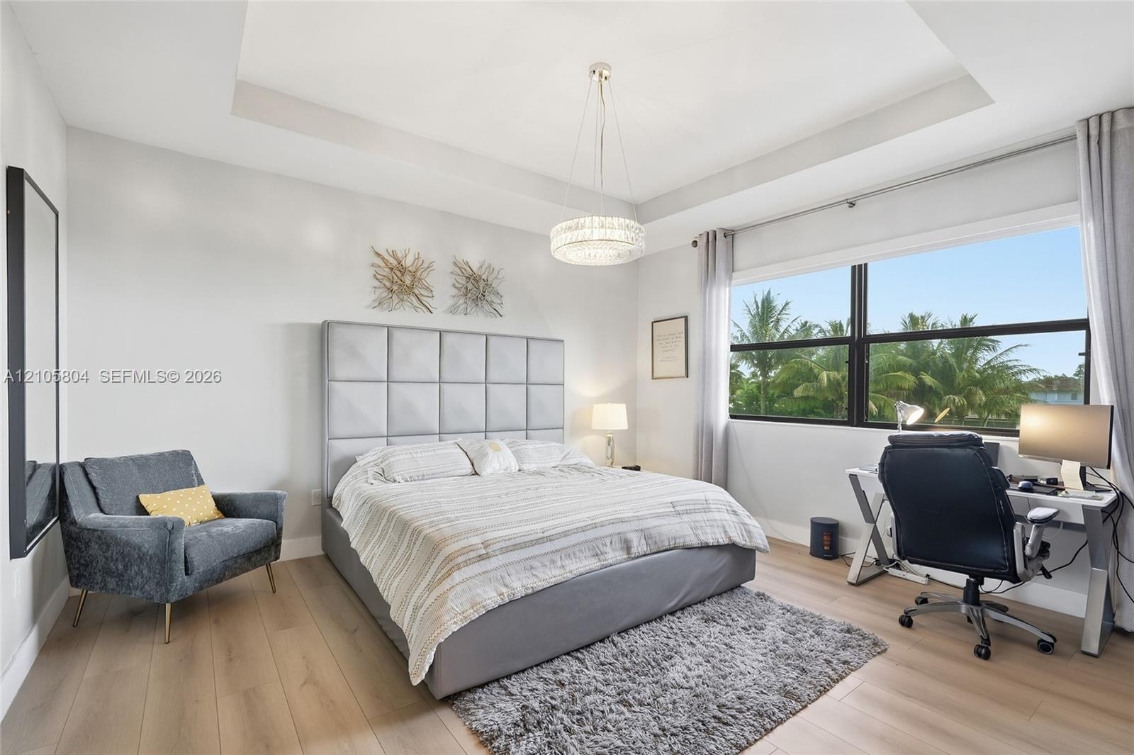 Tray ceiling with recessed lighting, wood-finish flooring, and expansive windows