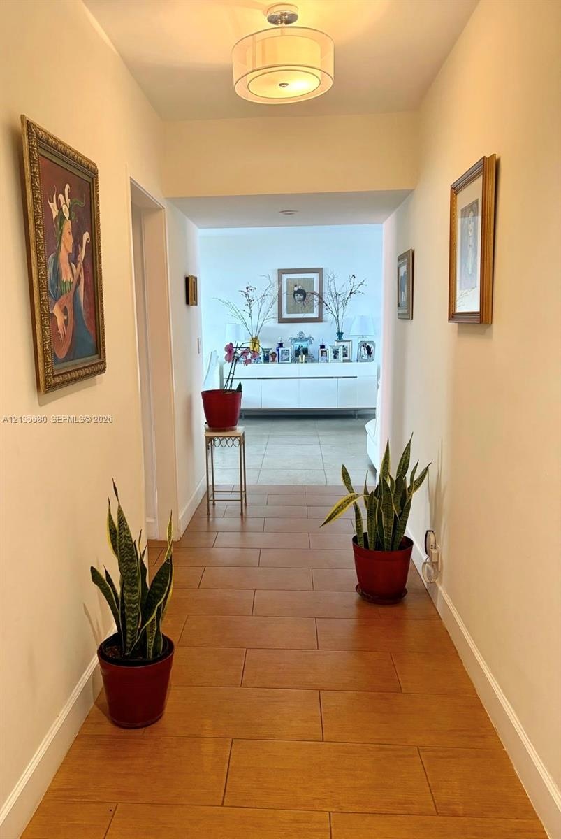 Interior hallway featuring tile flooring and a drum-style ceiling light fixture