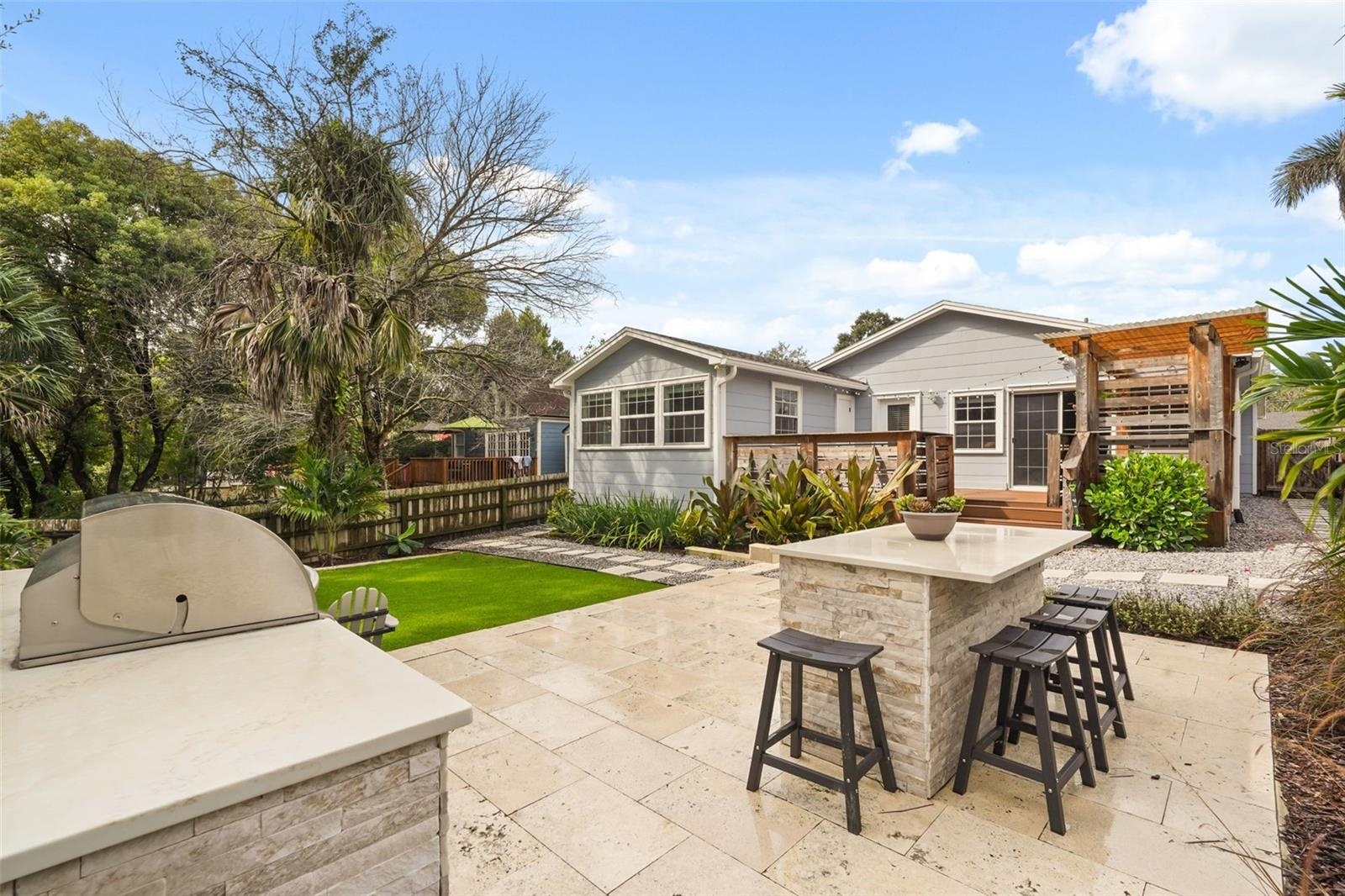 Outdoor kitchen with bar seating and view of the rear exterior