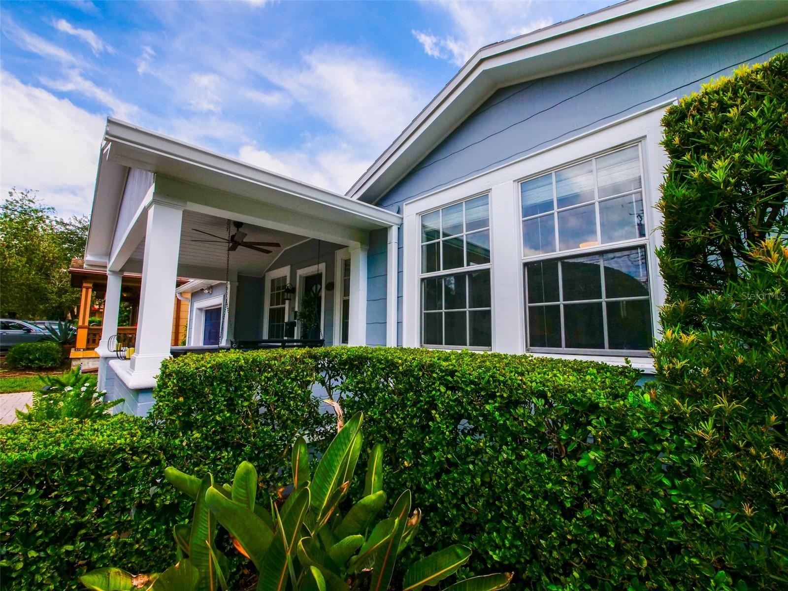 Covered front porch and front windows with landscaped hedges