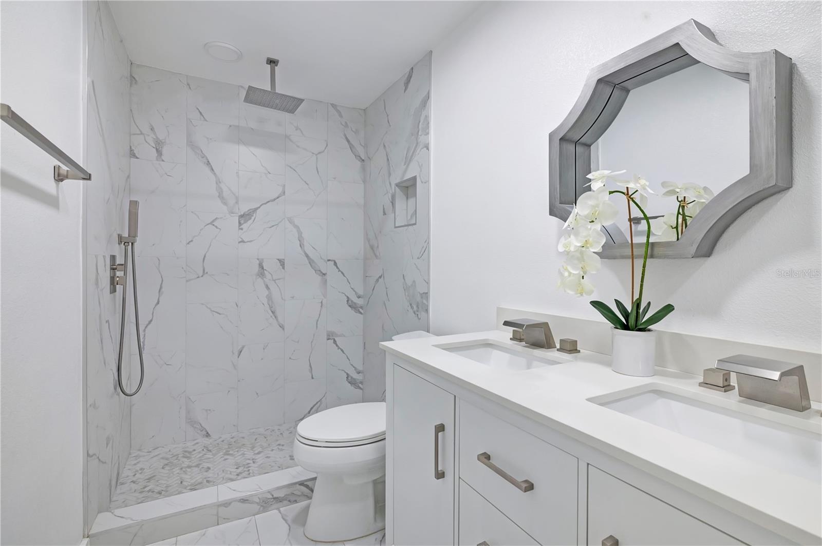 Fully renovated bathroom with double sinks and rain shower head