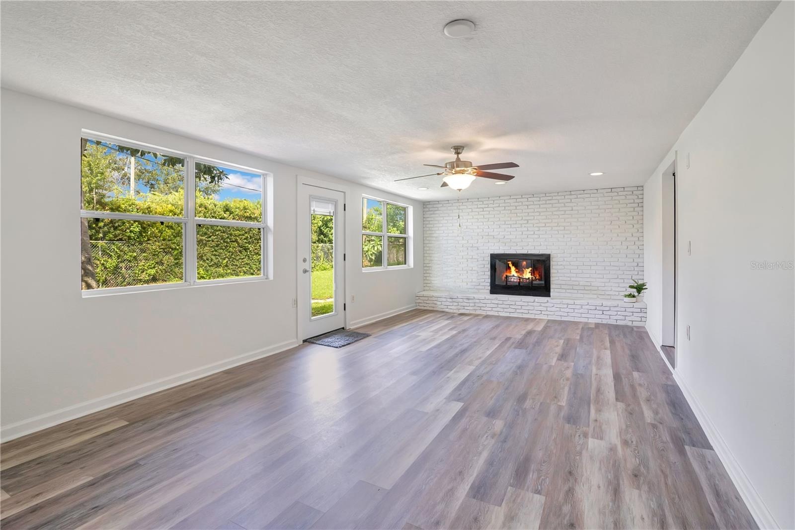 Family Room with wood-burning fireplace leading to backyard