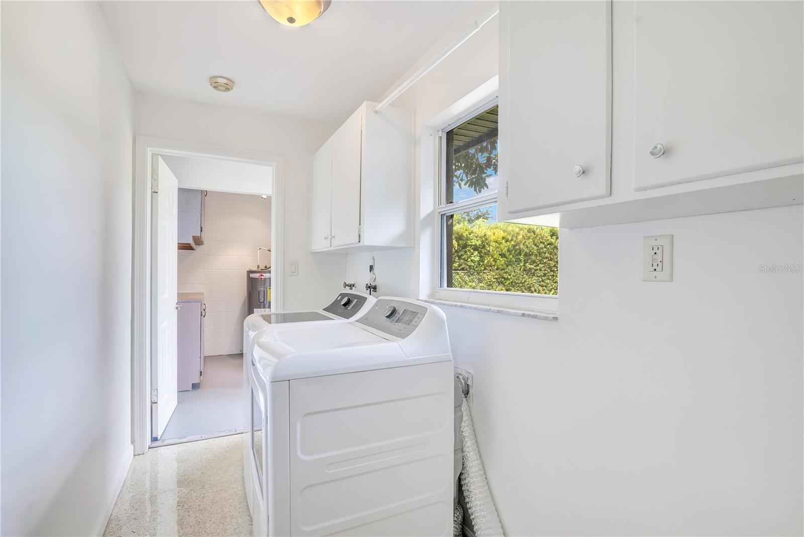 Indoor laundry room leading to workshop in garage
