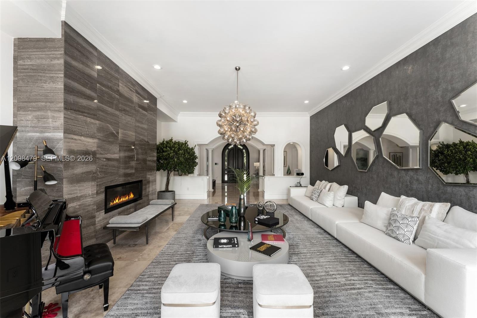 Recessed lighting illuminates a long wall featuring a linear fireplace and stone-finish paneling