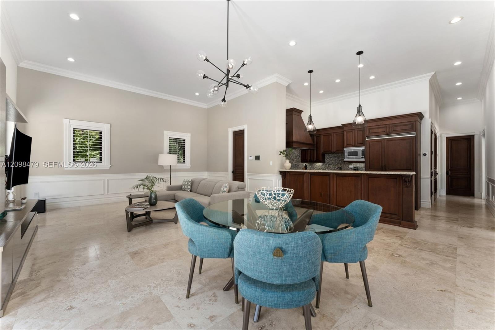 Vaulted ceilings with recessed lighting, crown molding, paneled wainscoting, wood-finish flooring, and built-in wood cabinetry