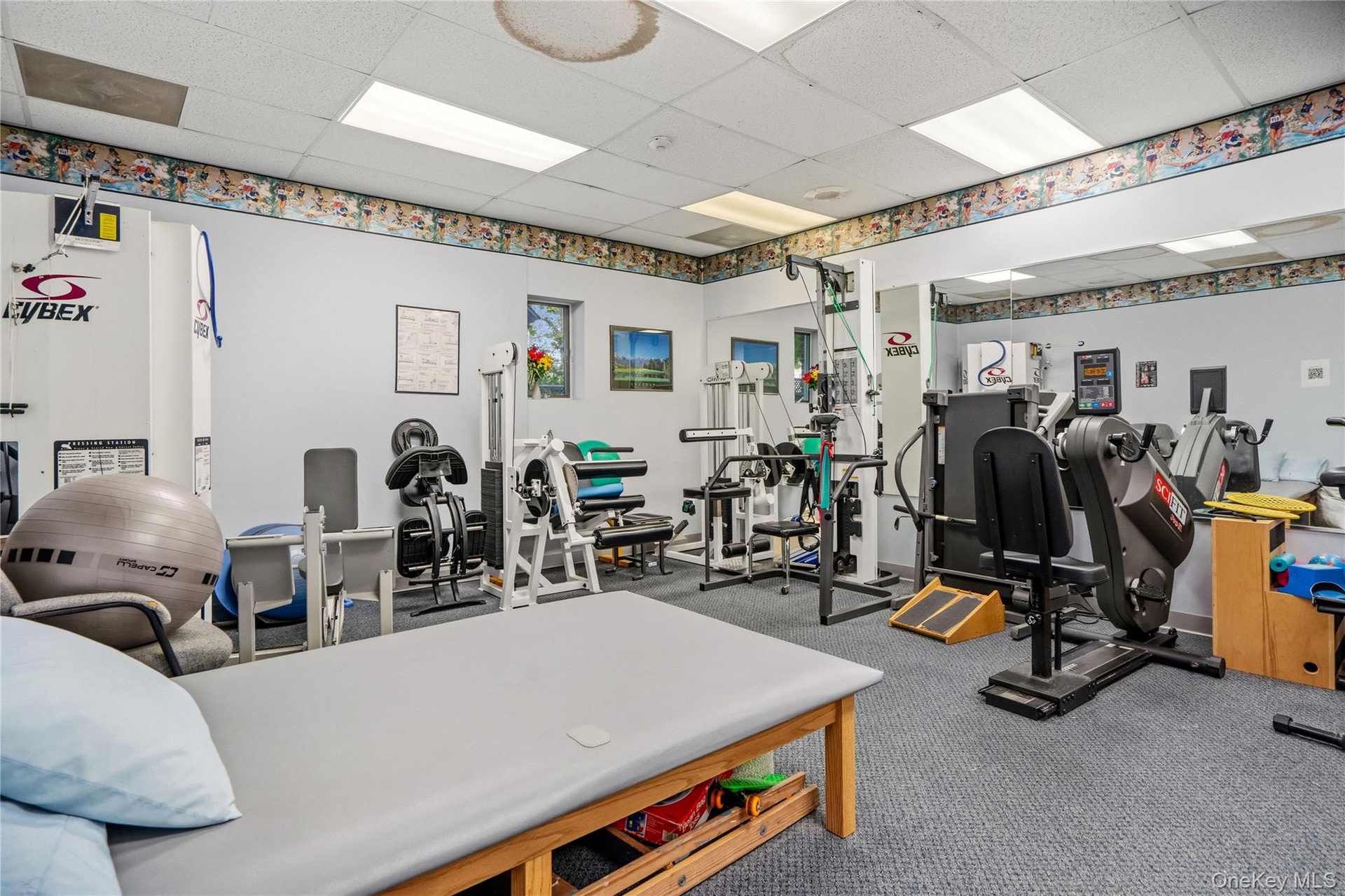 Multipurpose room featuring a drop ceiling with recessed lighting, wall-to-wall carpeting, and a large wall-mounted mirror