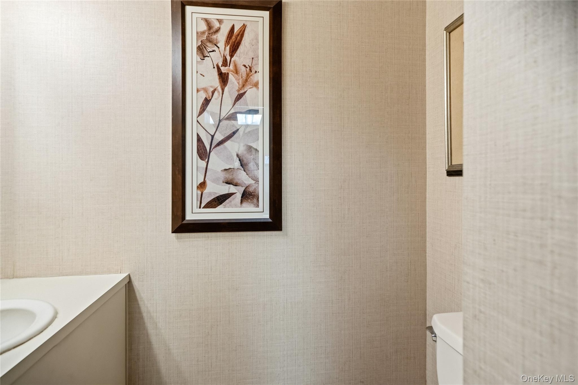 Textured wallpaper, integrated vanity with a circular basin, and a framed wall accent
