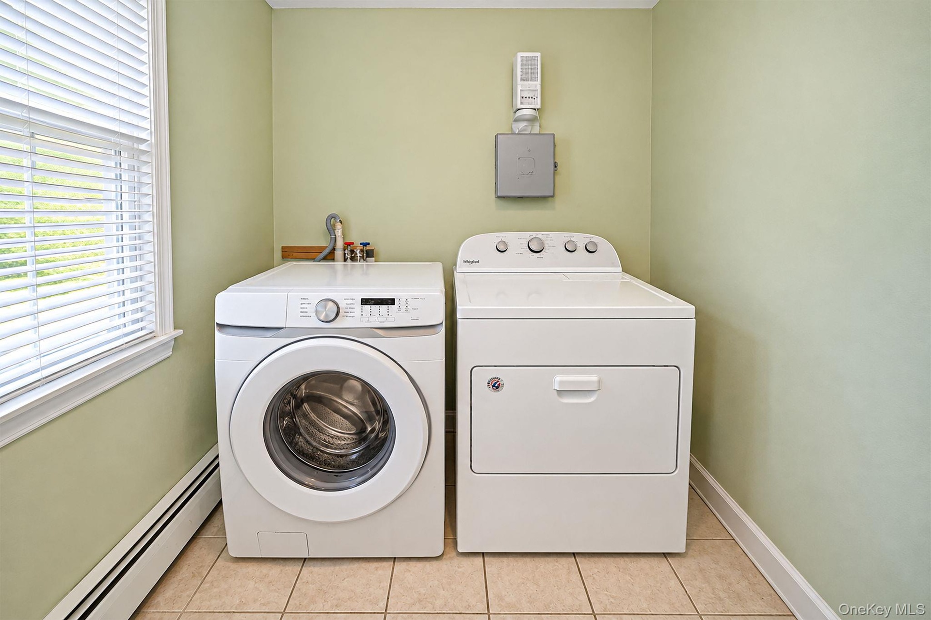 Laundry space featuring ceramic tile flooring, and dedicated hookups for washer and dryer.