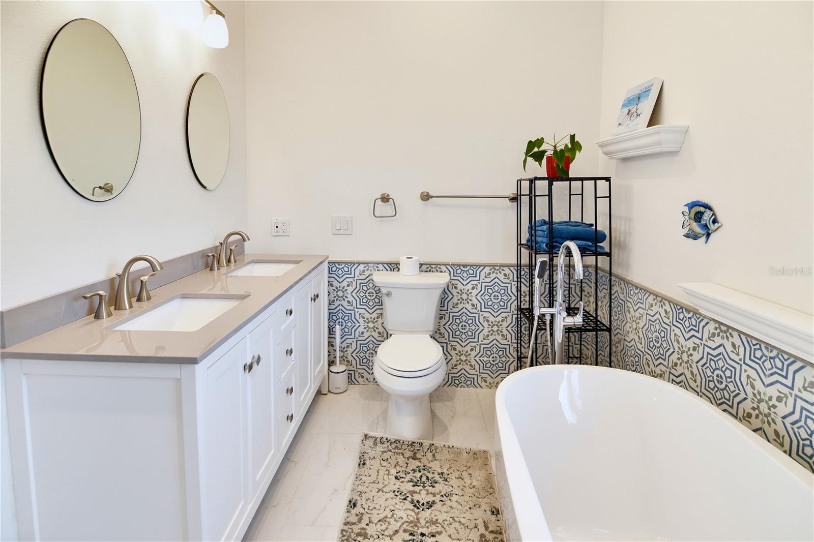 Spacious primary bathroom with double vanity, soaking tub, and beautifully coordinated finishes.