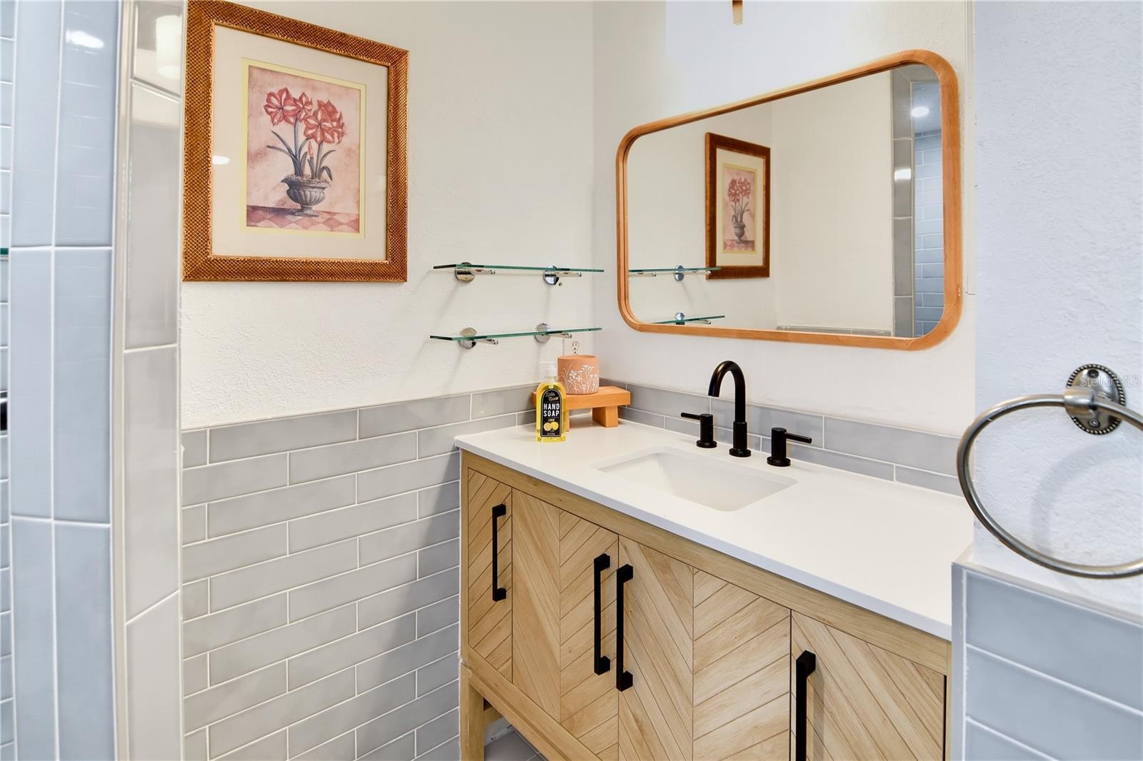 Stylish bathroom vanity with modern fixtures, attractive tilework, and generous counter space.