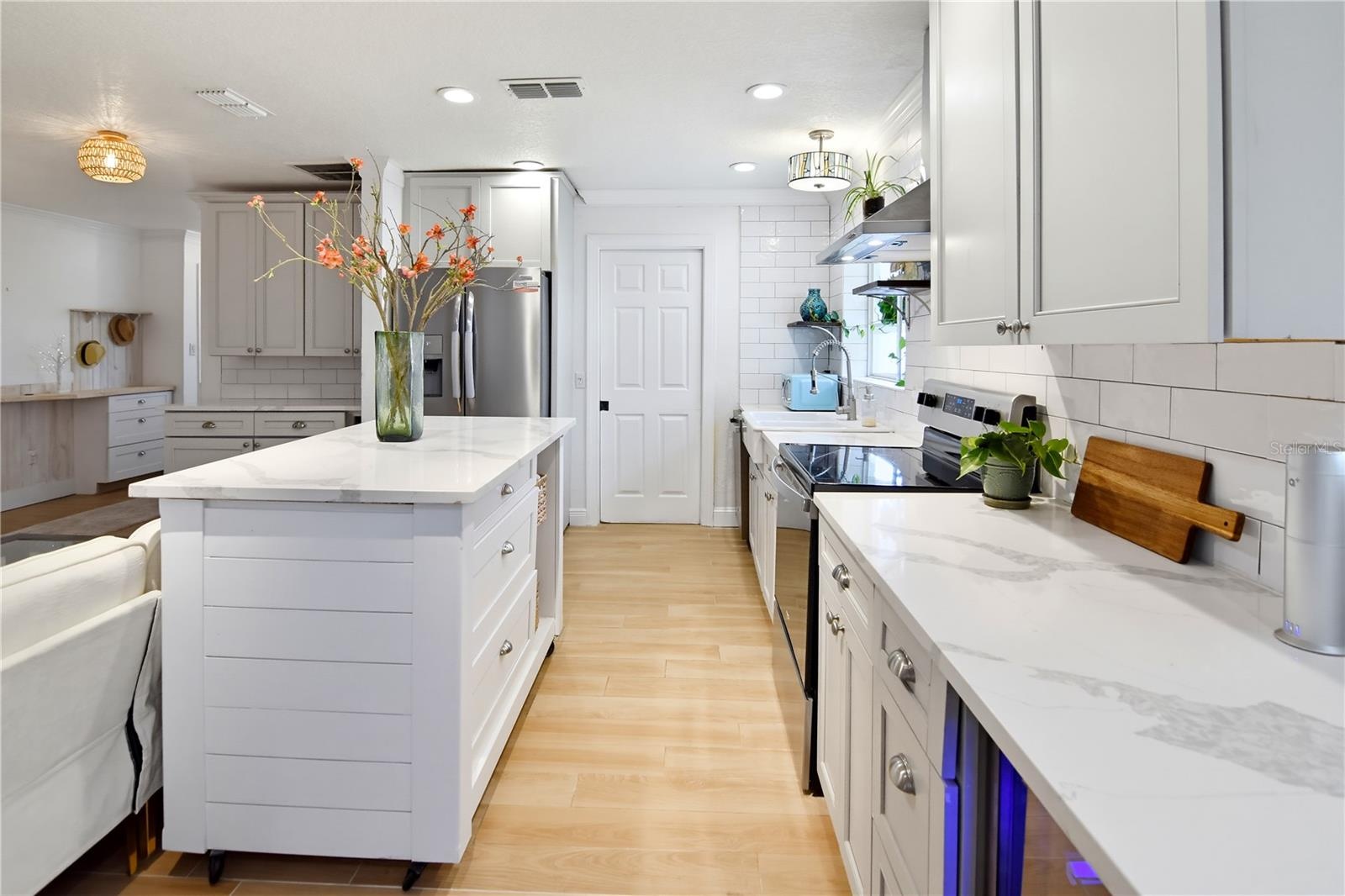 Updated kitchen featuring quartz countertops, stainless steel appliances, and a spacious center island.