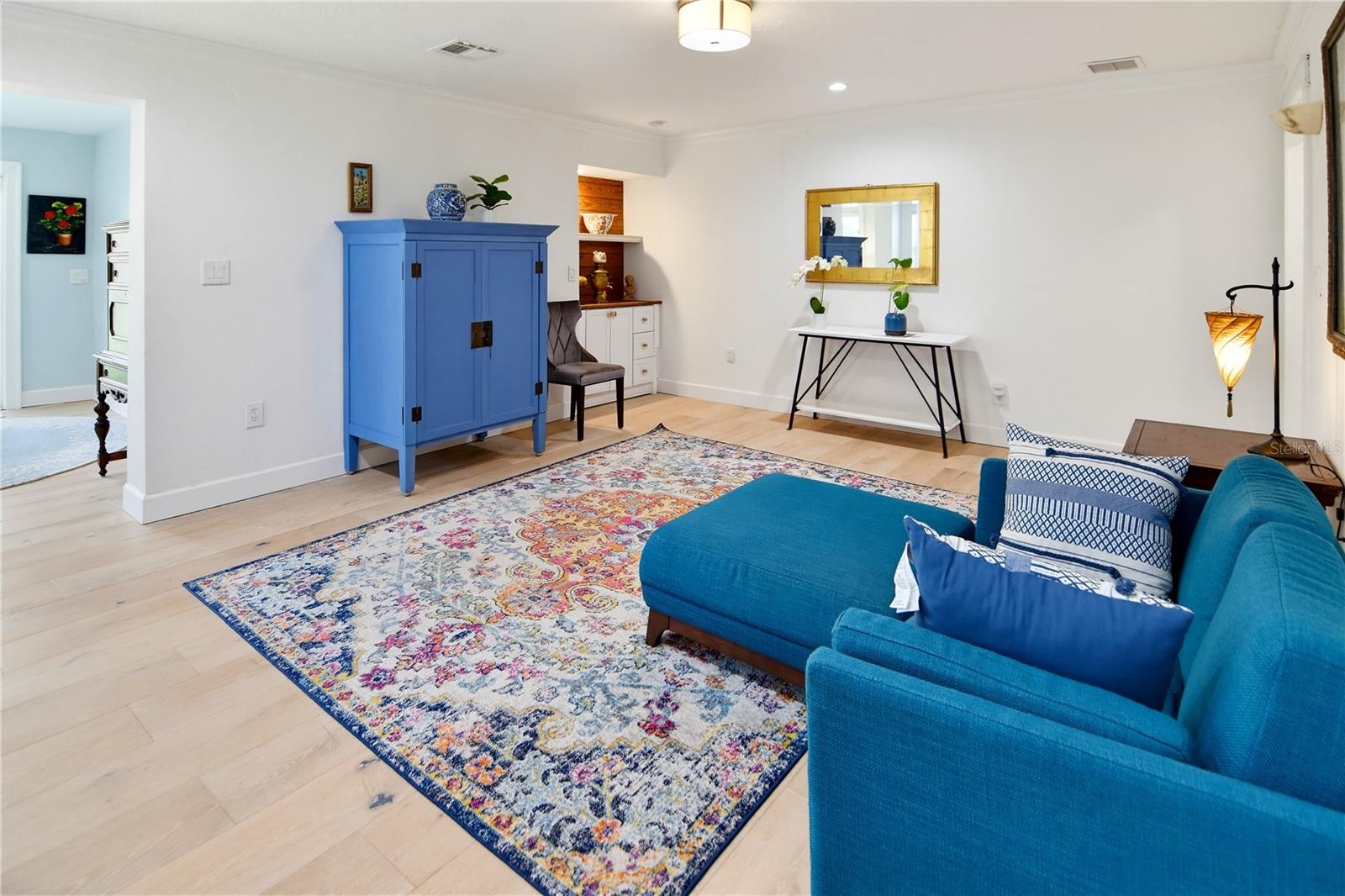 Spacious family room with flexible furniture arrangements and attractive flooring.