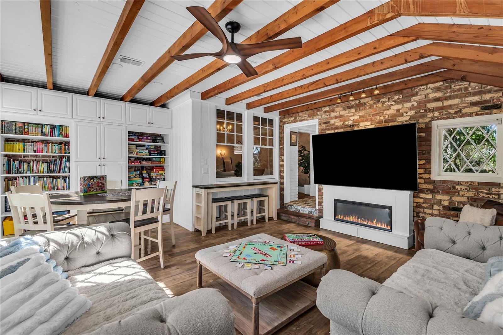 Natural light pours into the spacious family room that features warm brick walls, exposed wood beams and distinctive diamond-pane windows that create 