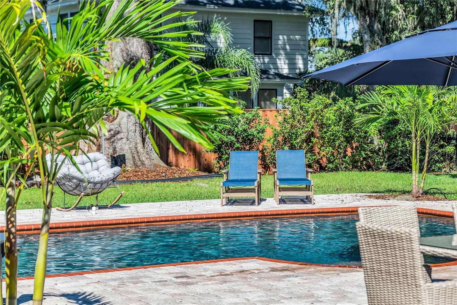 The enormous fully fenced backyard is designed for year-round enjoyment with a gas-heated saltwater sport pool, outdoor kitchen, expansive brick paved