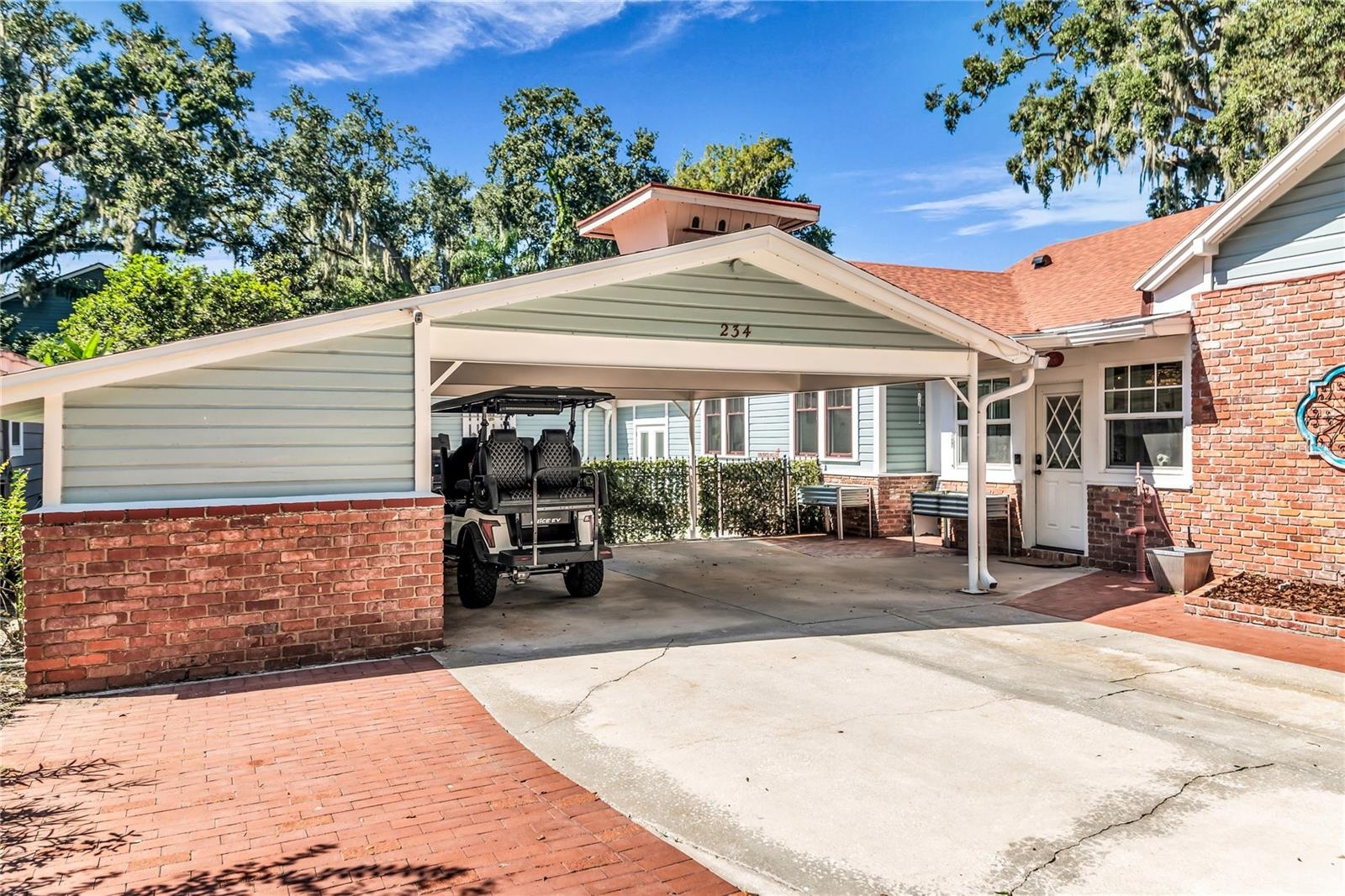 Double Carport includes both a Tesla and golf cart charging station as well as a large storage closet equipped with power and a shop desk.