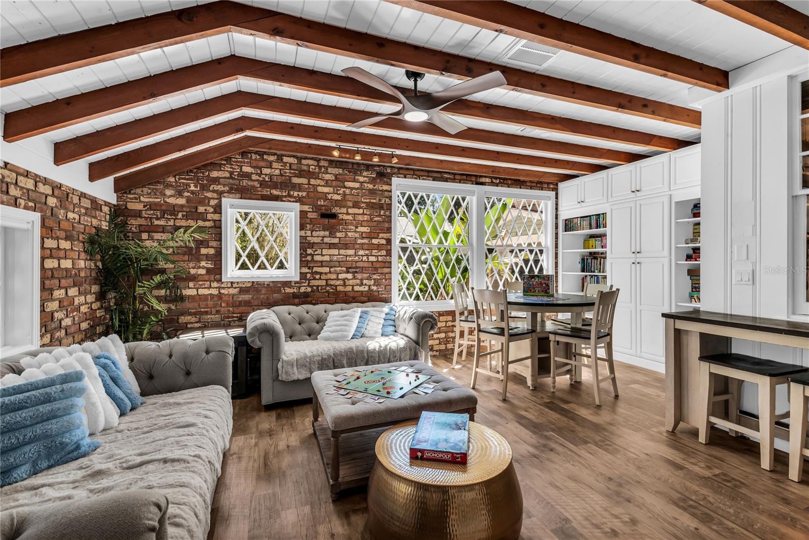 Natural light pours into the spacious family room that features warm brick walls, exposed wood beams and distinctive diamond-pane windows that create 