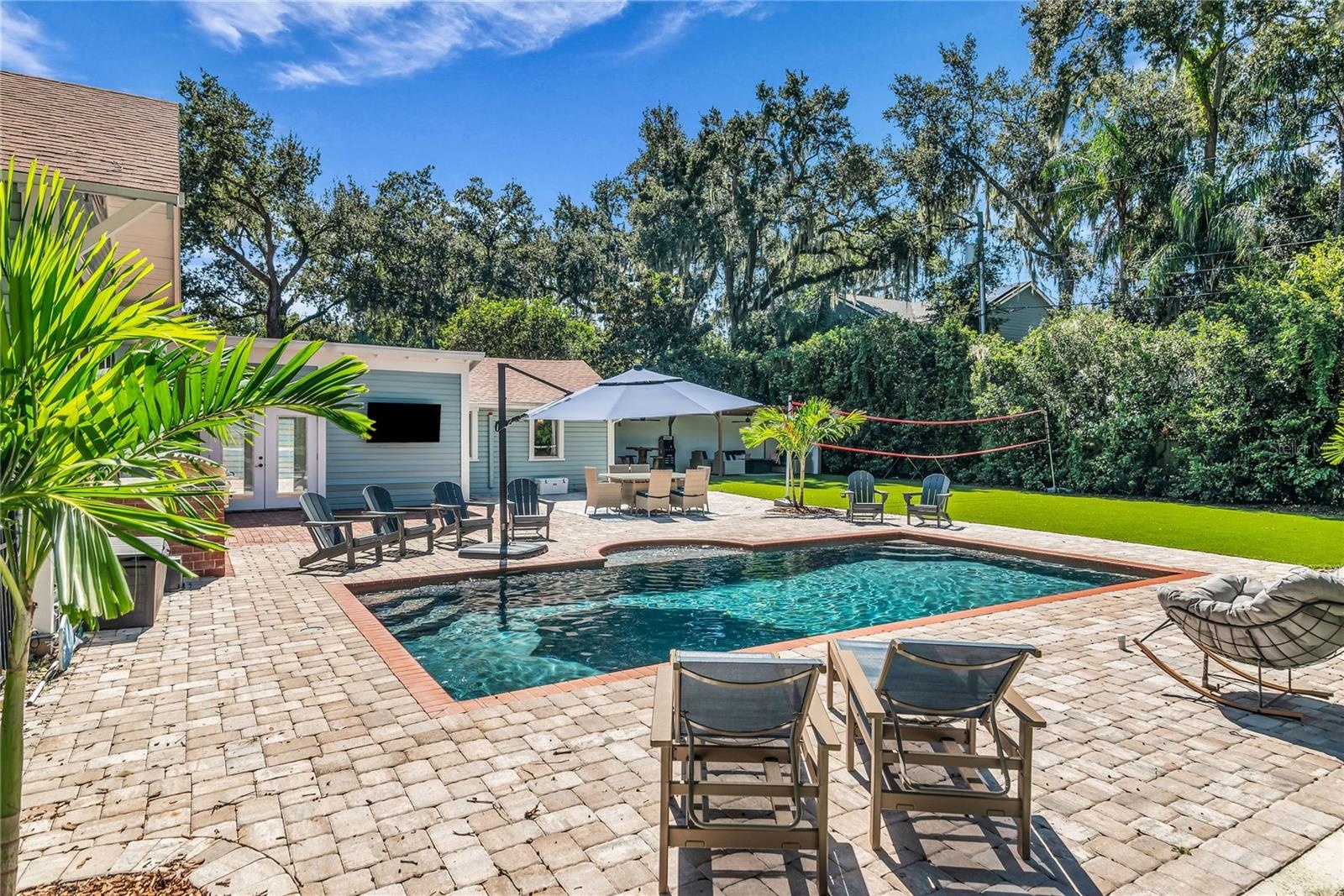 The enormous fully fenced backyard is designed for year-round enjoyment with a gas-heated saltwater sport pool, outdoor kitchen, expansive brick paved