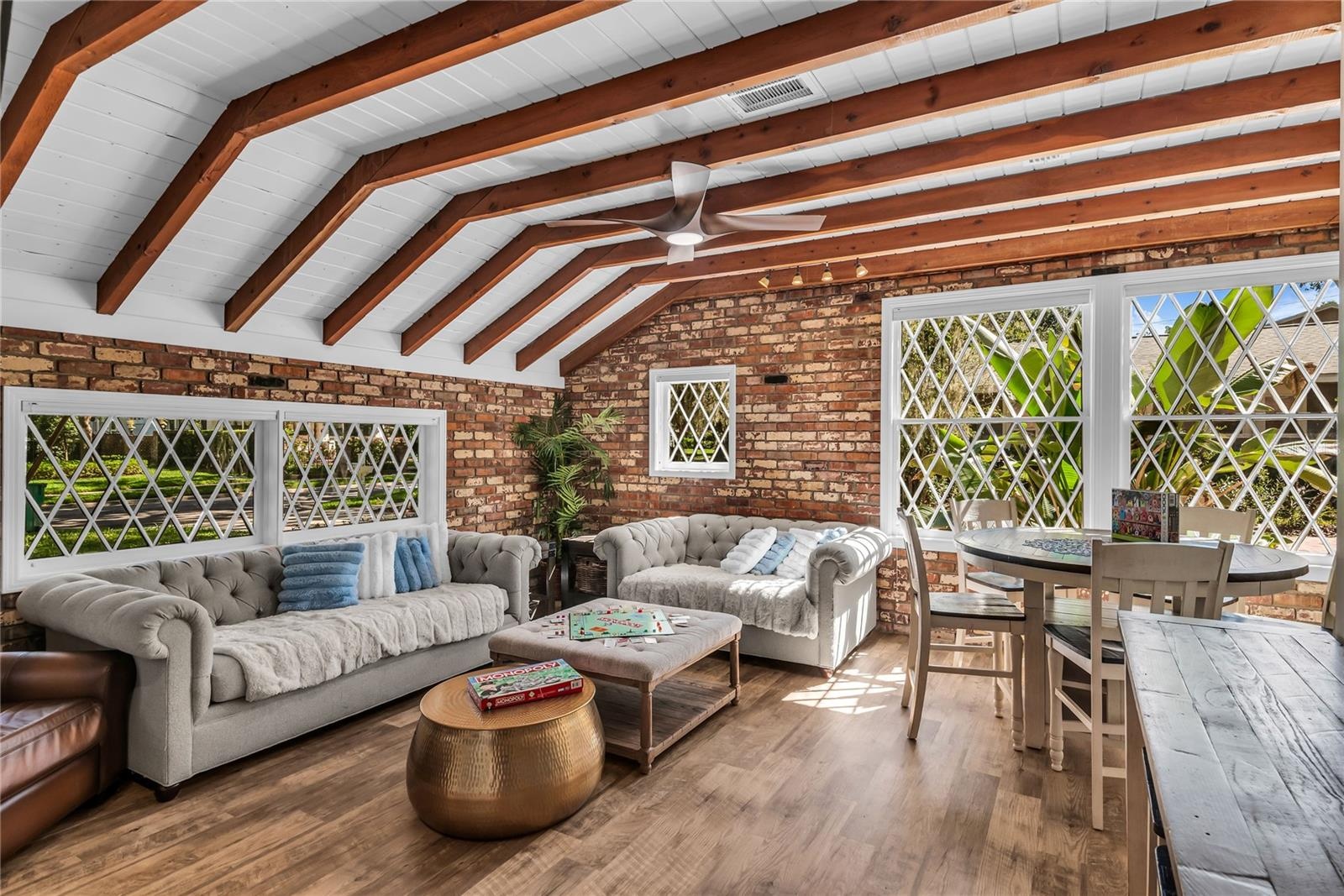 Natural light pours into the spacious family room that features warm brick walls, exposed wood beams and distinctive diamond-pane windows that create 