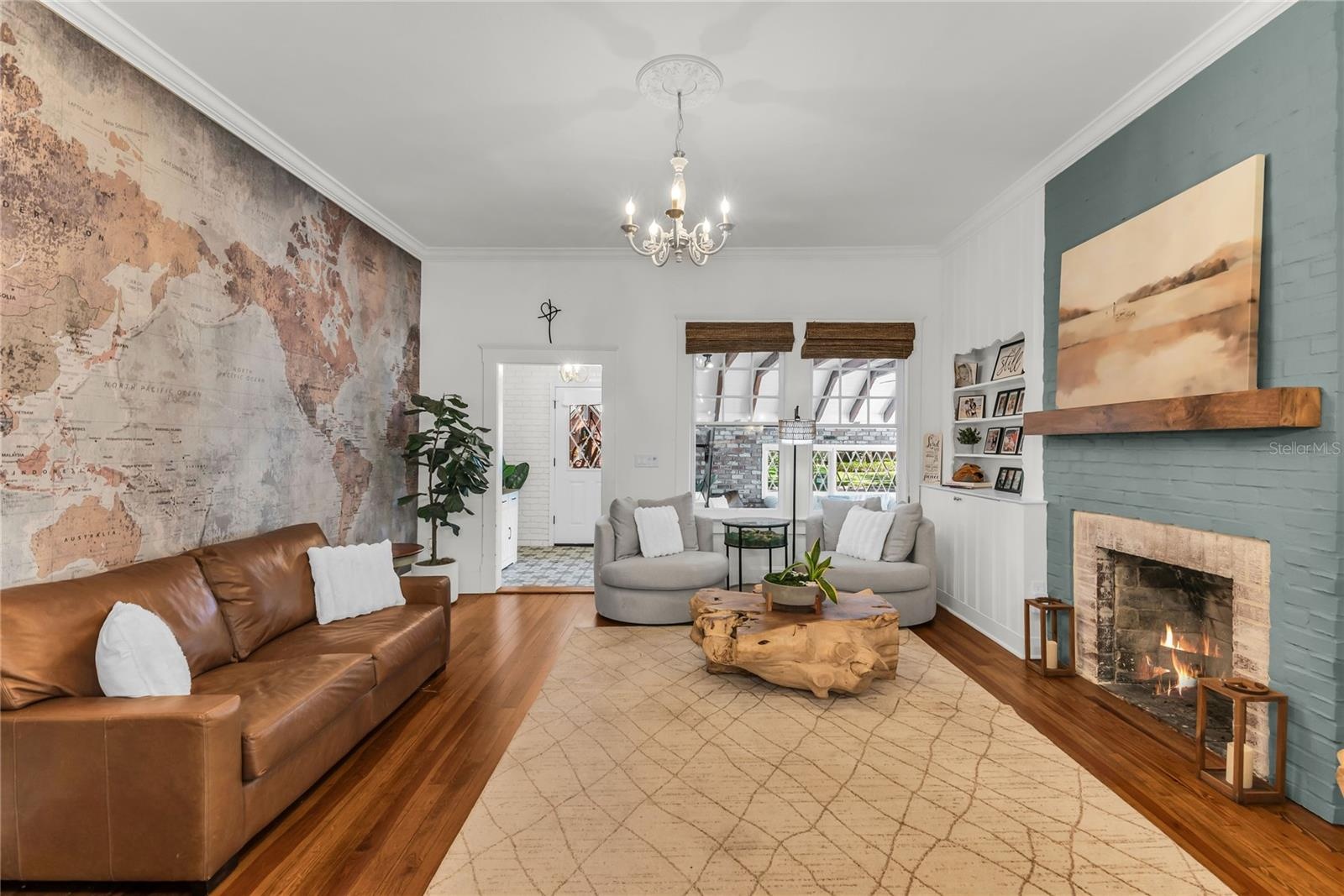 The warm and welcoming Formal Living Room is anchored by a wood-burning brick fireplace accented by a substantial wood mantle and custom painted brick