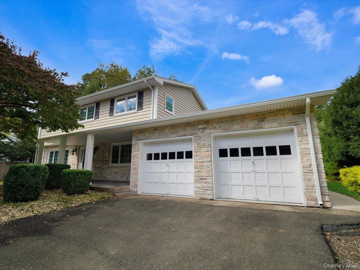 Center hall colonial with stone facade and new vinyl siding.