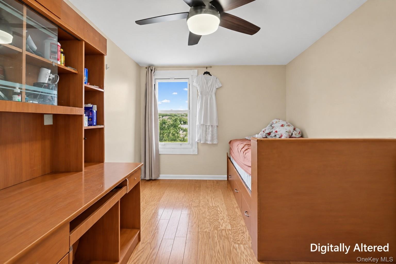 Wood-finish flooring, ceiling fan with integrated lighting, and a window