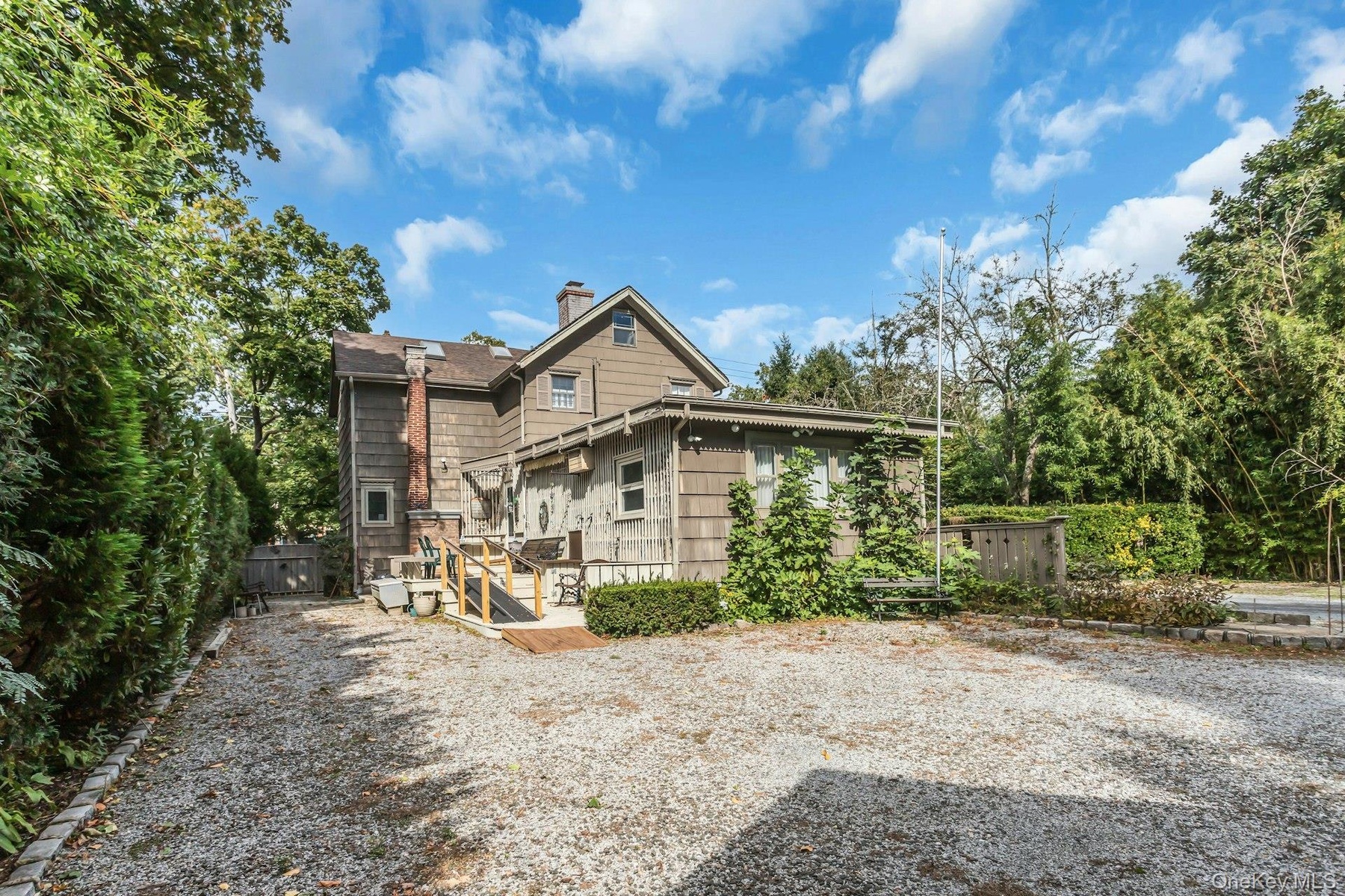Shingle siding exterior with a multi-level structure and a prominent brick chimney