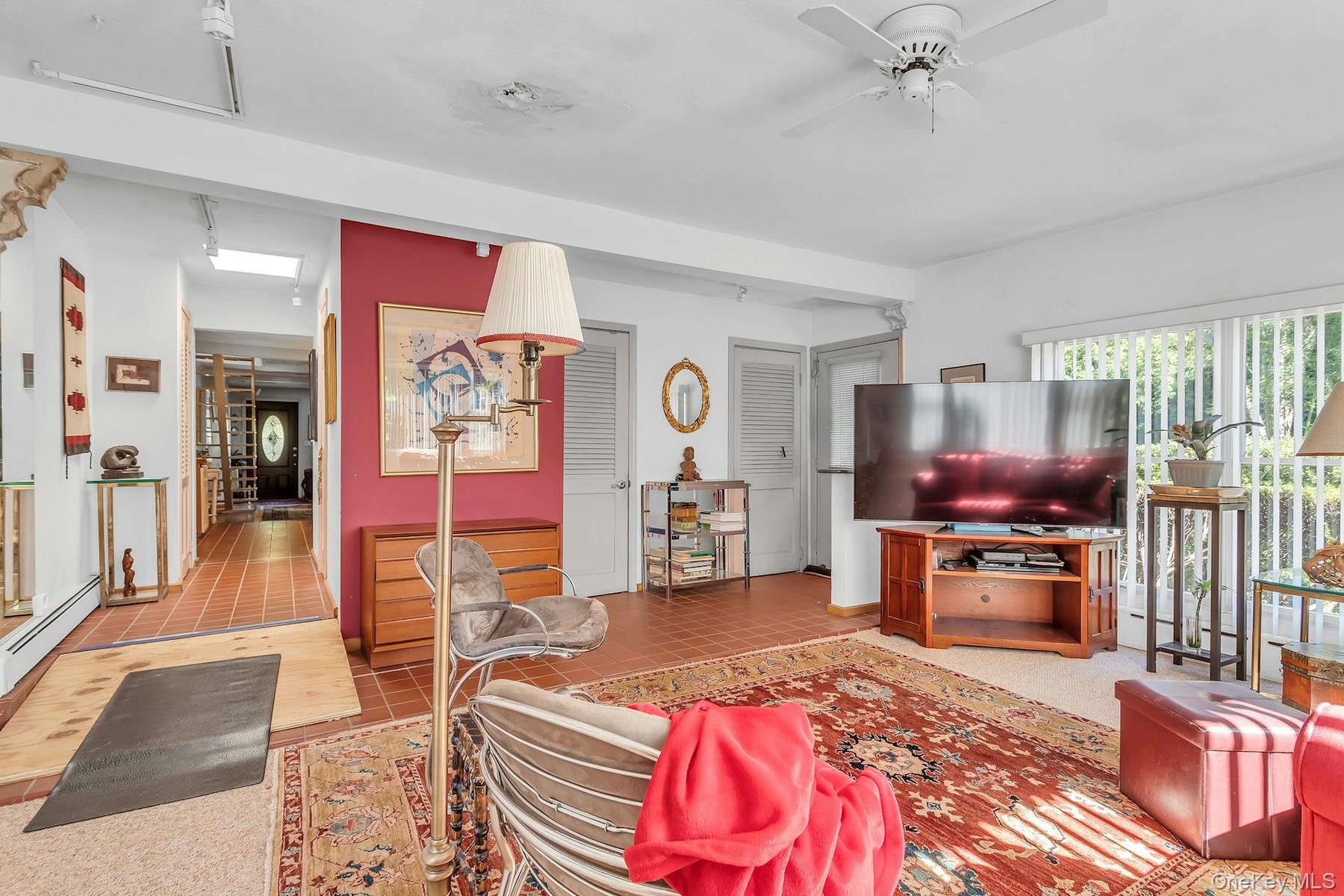 Spacious living area featuring a ceiling fan, recessed lighting, and tile flooring