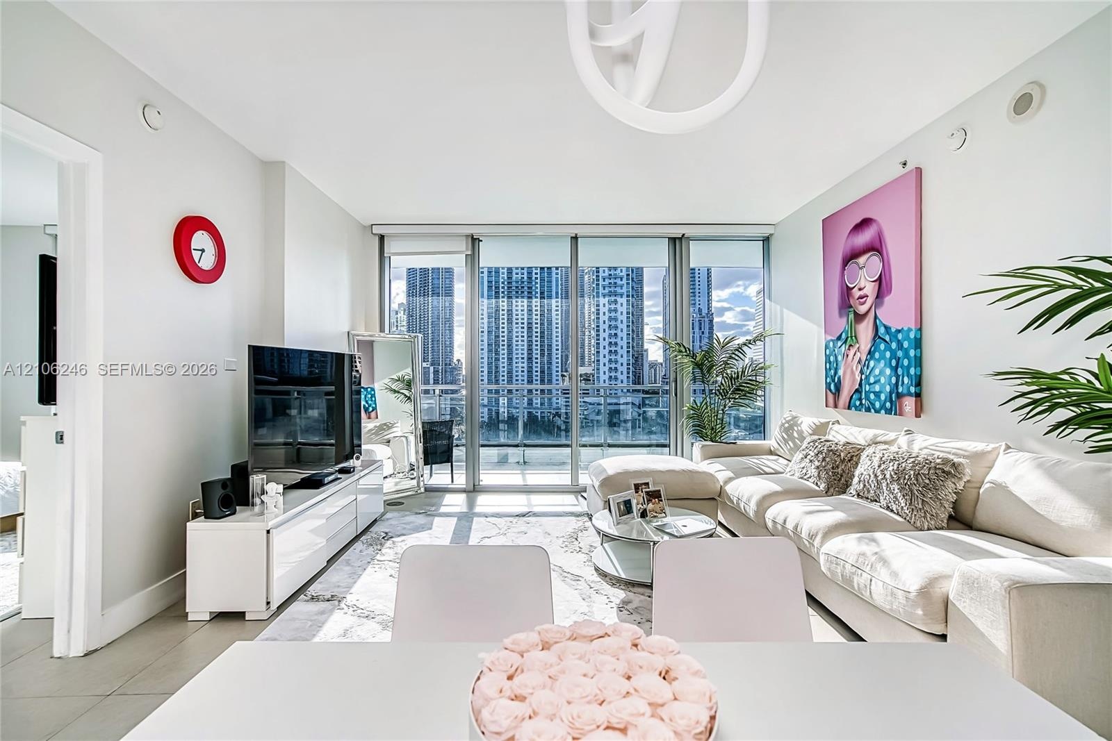 Living area featuring floor-to-ceiling windows, porcelain tile flooring, and urban skyscraper scenery