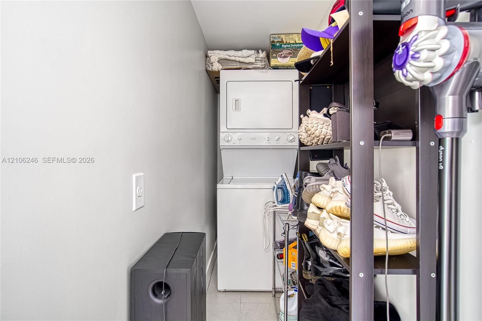 Stacked white laundry unit featuring integrated dryer and washing machine