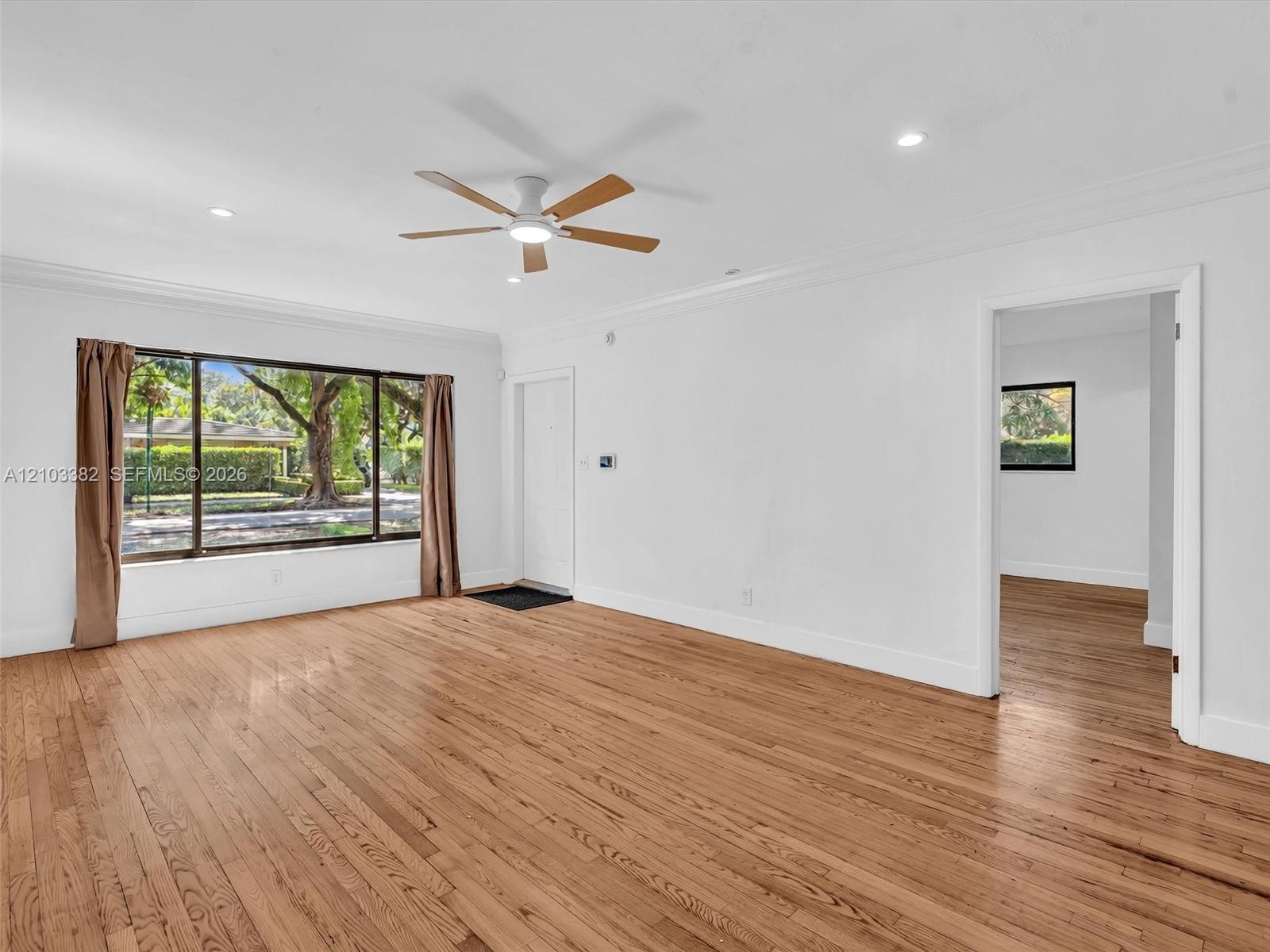 Living room view featuring wood-finish flooring, crown molding, recessed lighting, and a ceiling fan. House for rent in Coral Gables. House for rent l