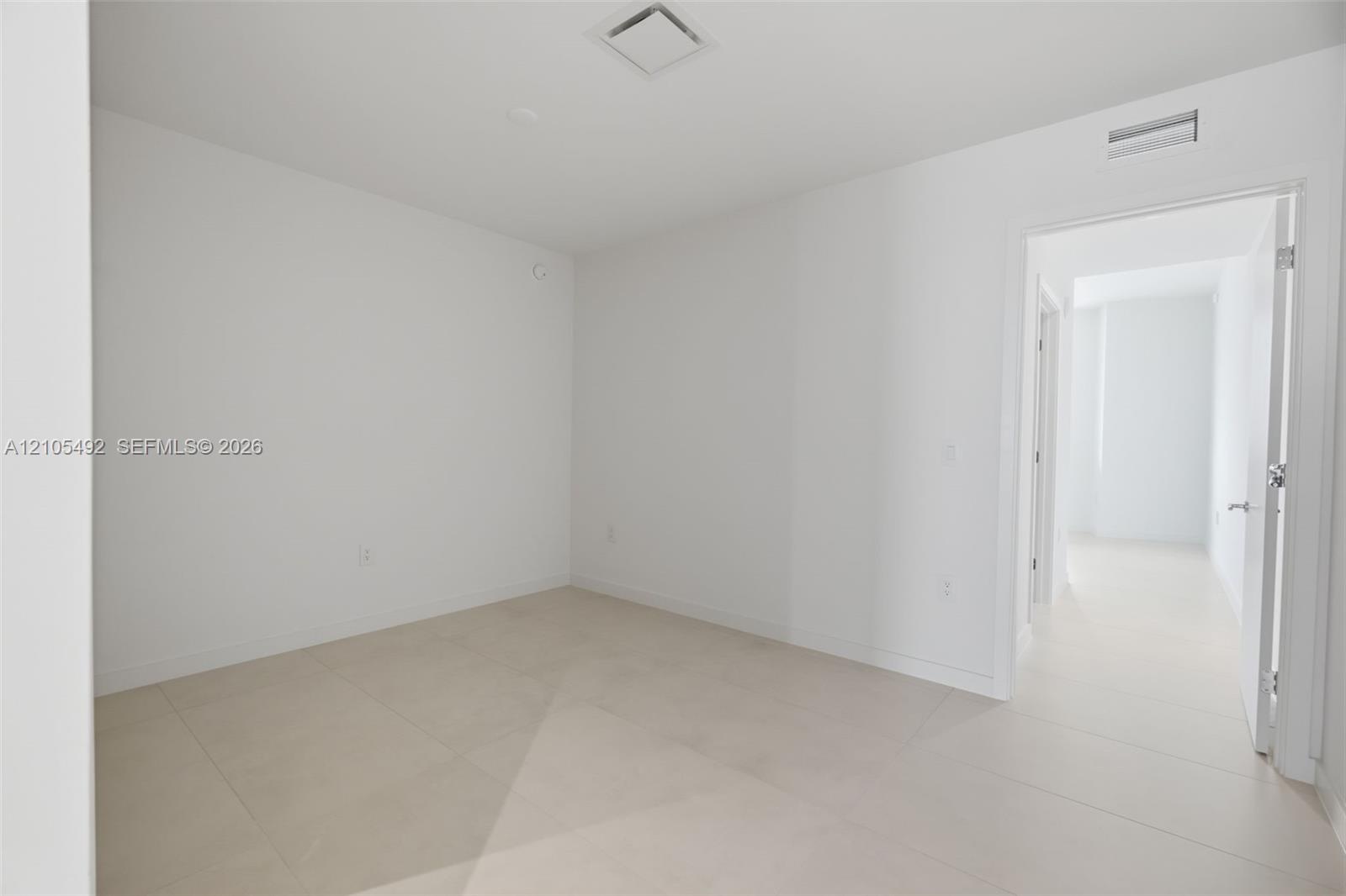 Neutral-toned large-format tile flooring and minimalist crisp white walls