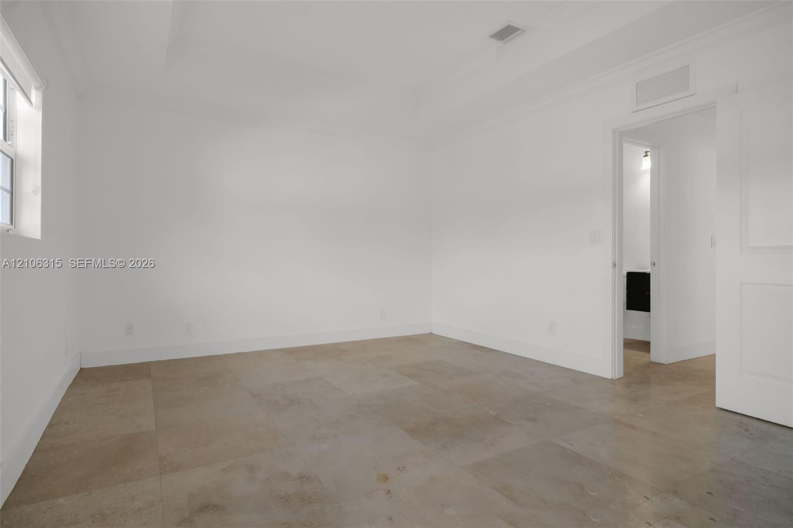 Neutral-toned tile flooring, recessed ceiling detailing, and crisp white wall finishes