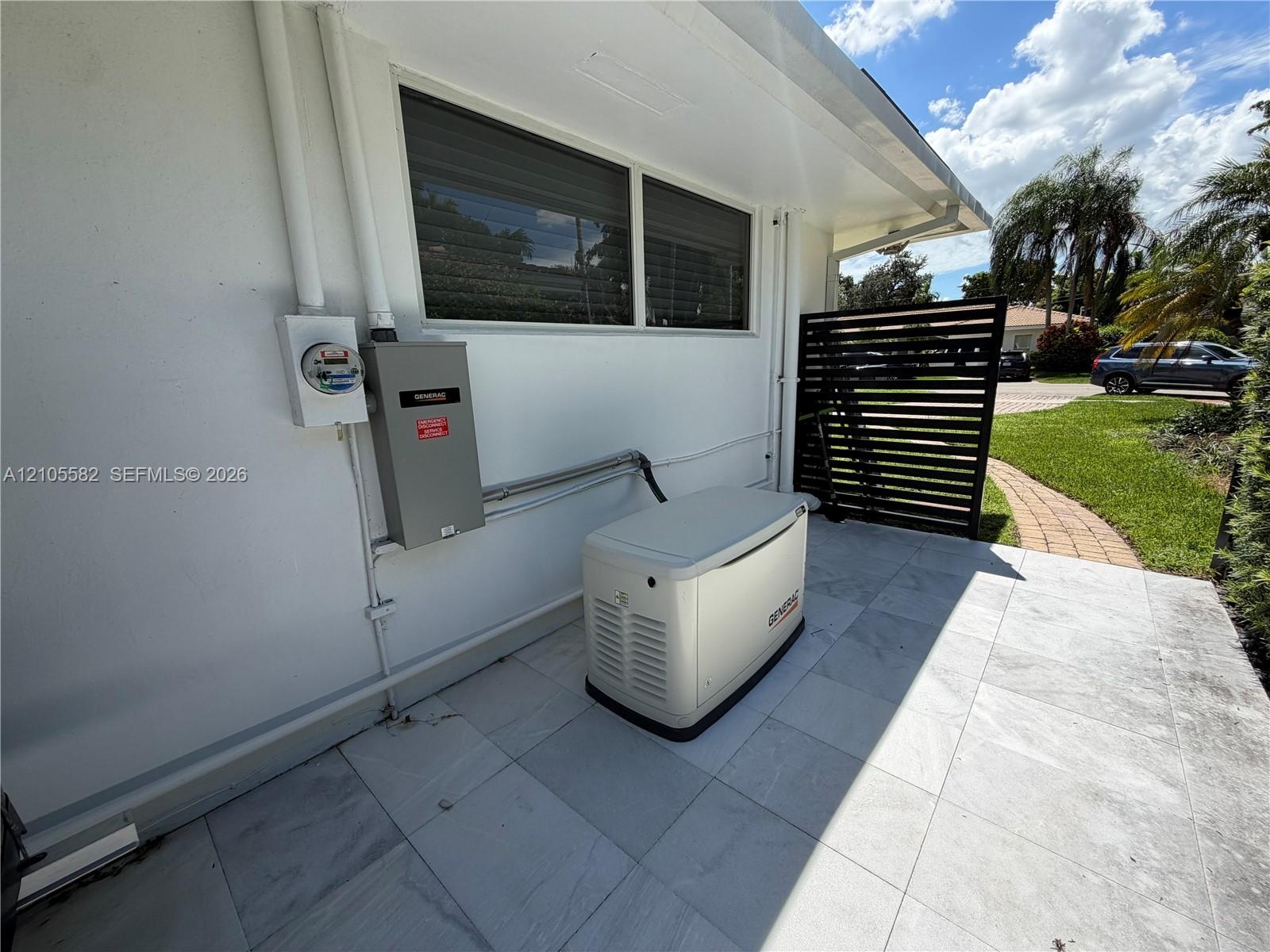 Exterior wall with a Generac standby generator, a service meter, and a primary electrical panel